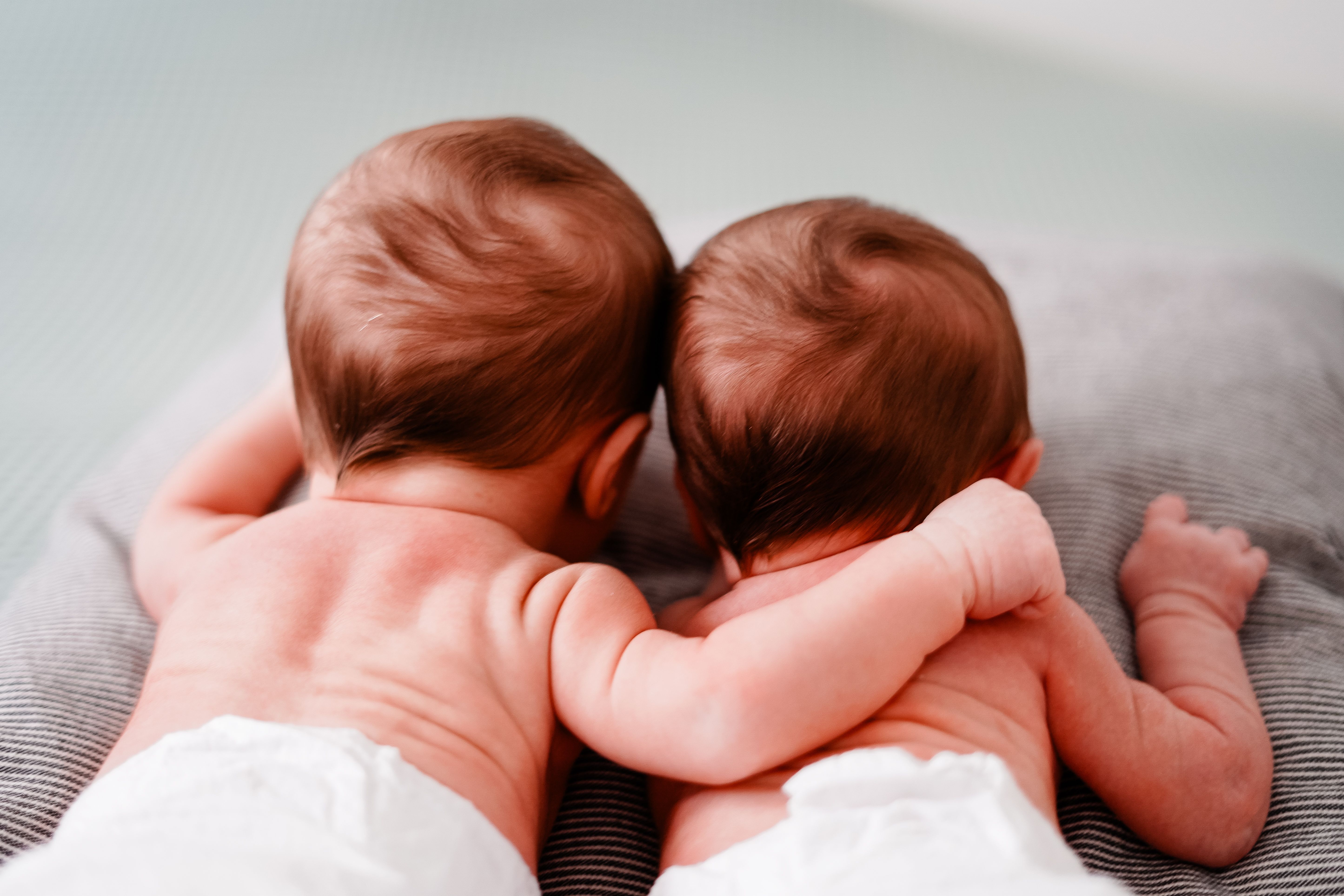Dos bebés de espaldas a la cámara | Fuente: Pexels