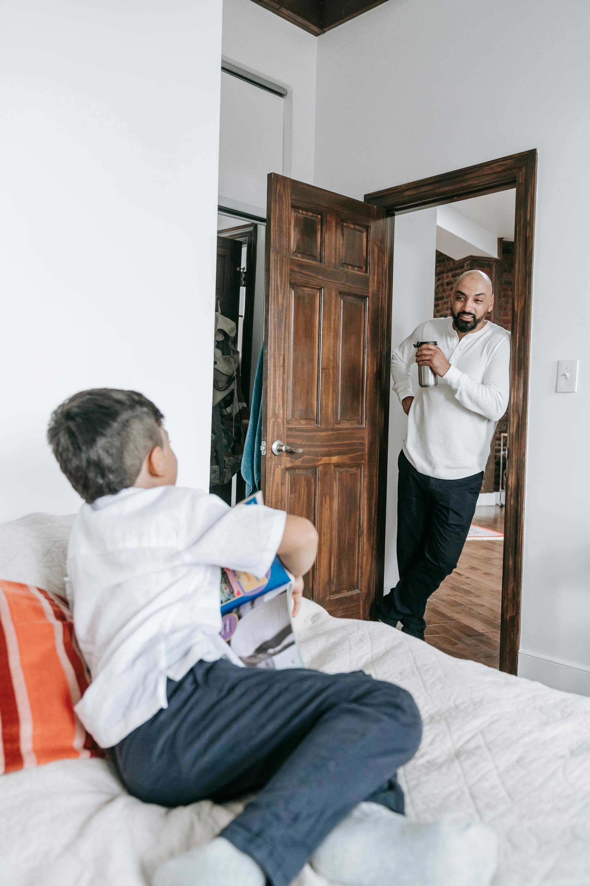 Un padre hablando con su hijo pequeño en casa | Fuente: Pexels