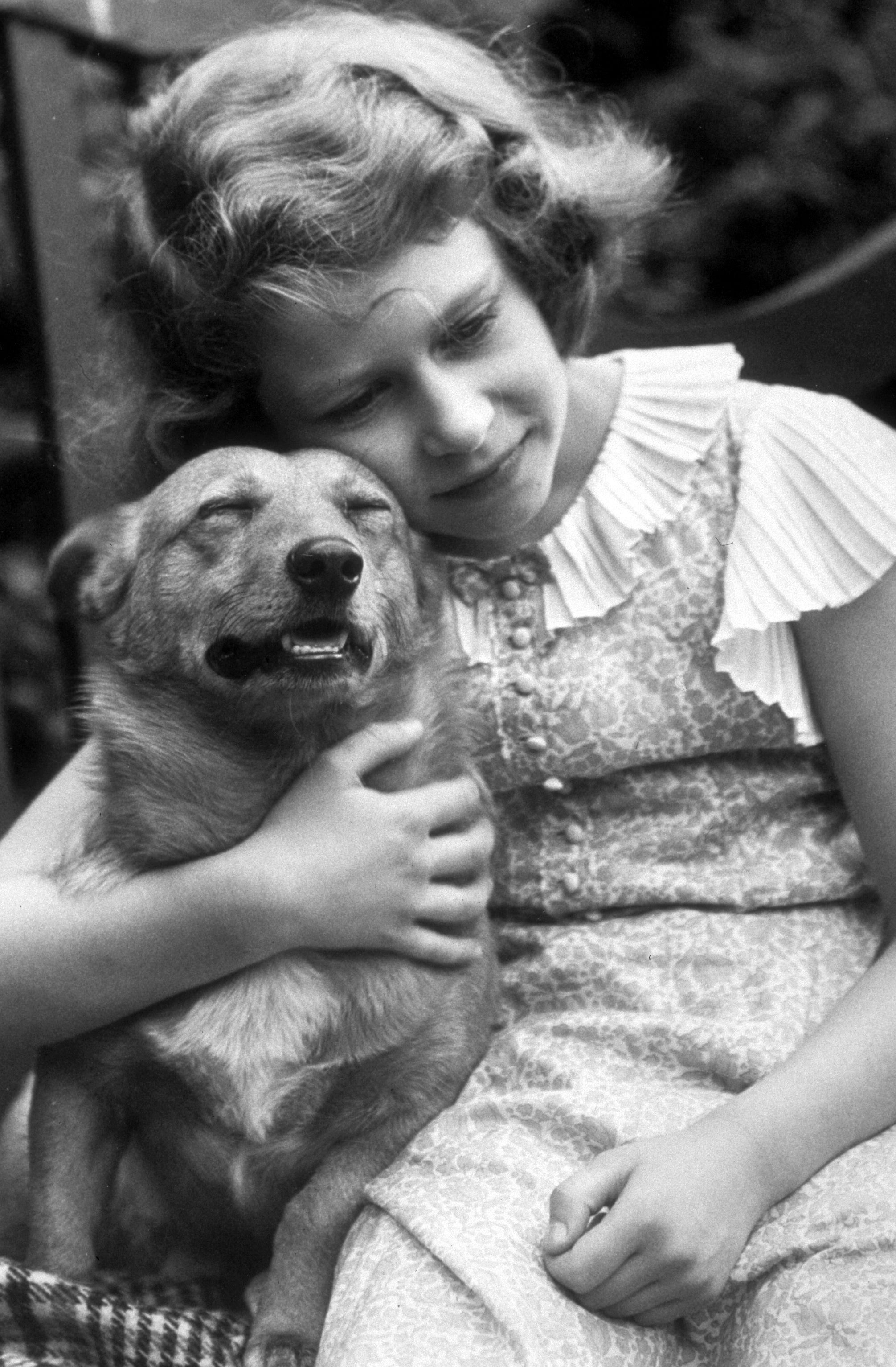 La princesa Elizabeth se fotografió abrazando a un Corgi en julio de 1936. | Foto: Getty Images