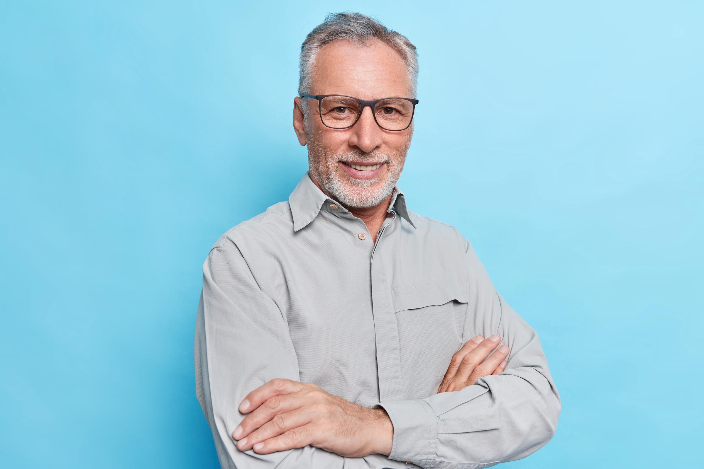 Un hombre sonriente de mediana edad con los brazos cruzados | Fuente: Freepik