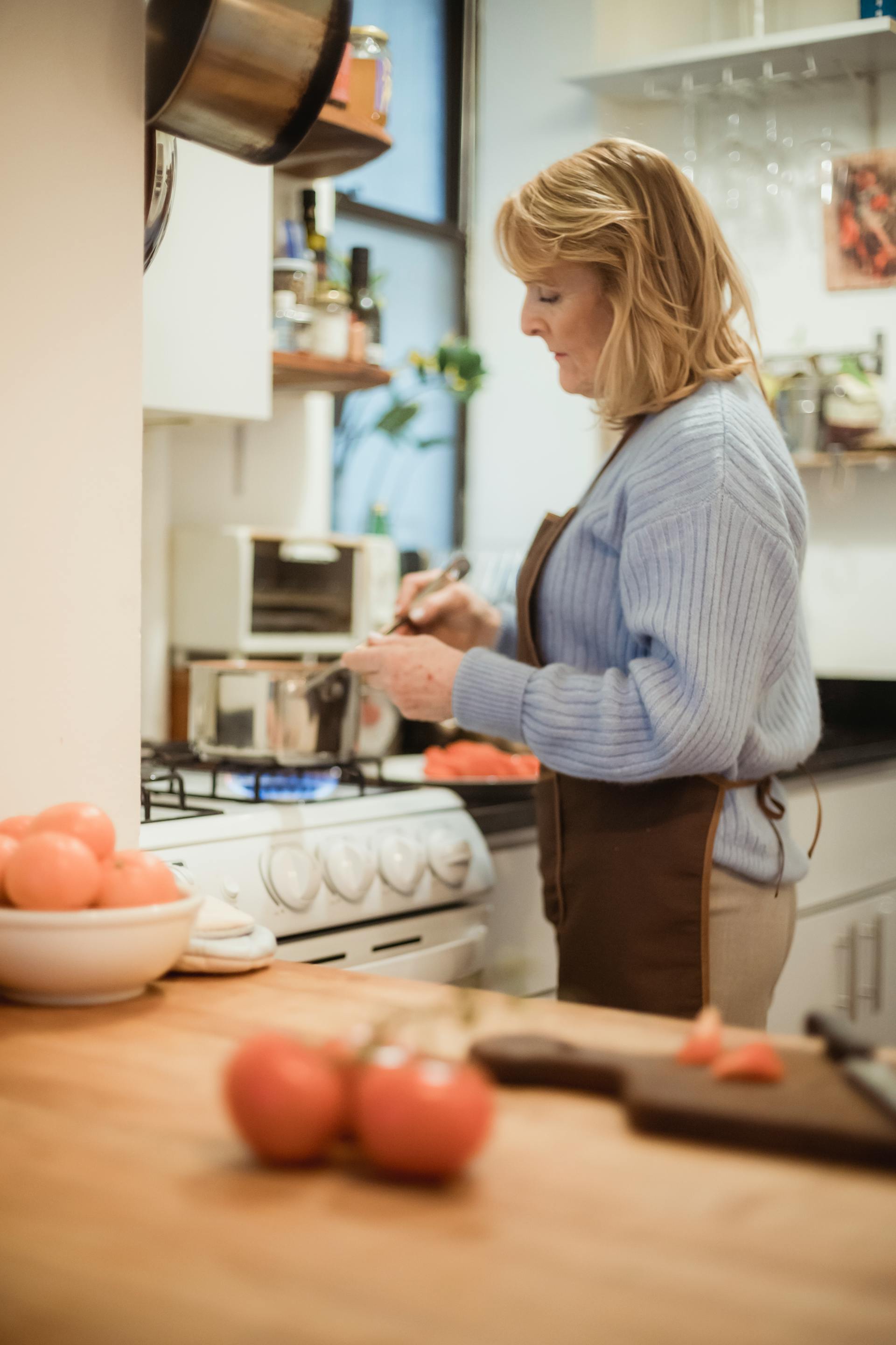 Mujer madura cocinando en la cocina | Fuente: Pexels