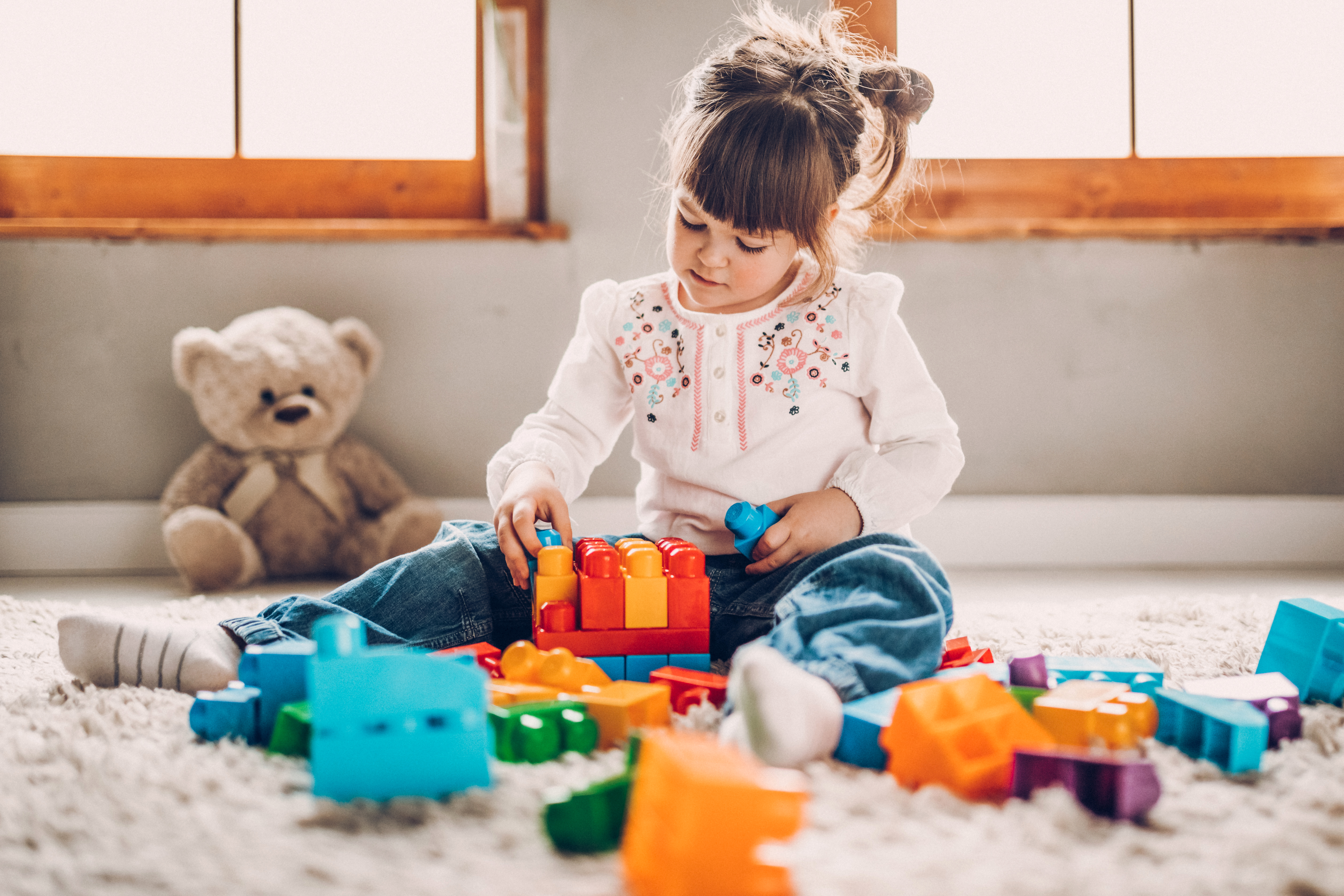 Dulce niño jugando con bloques de plástico | Foto: Getty Images