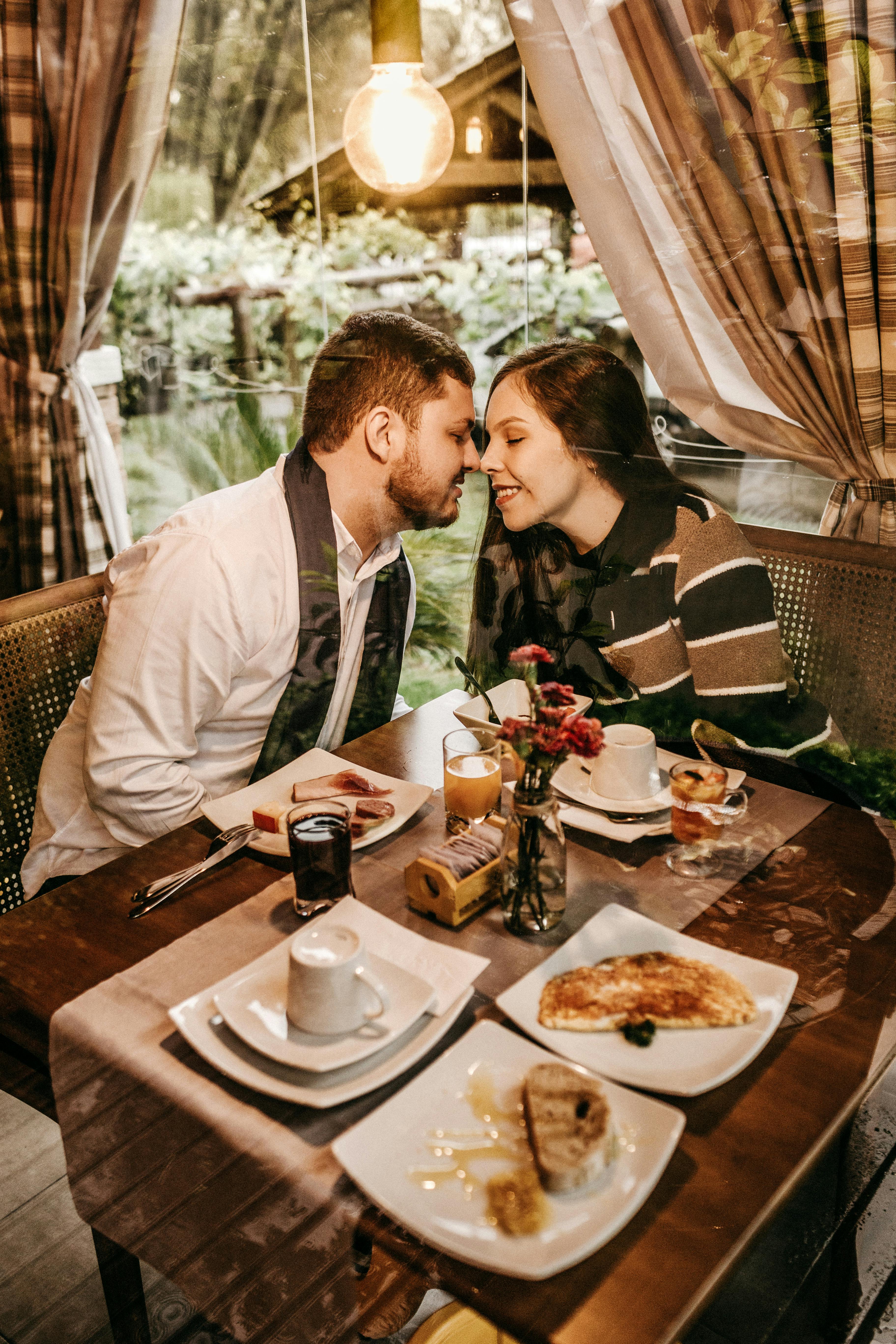Una pareja a punto de besarse en un restaurante | Fuente: Pexels