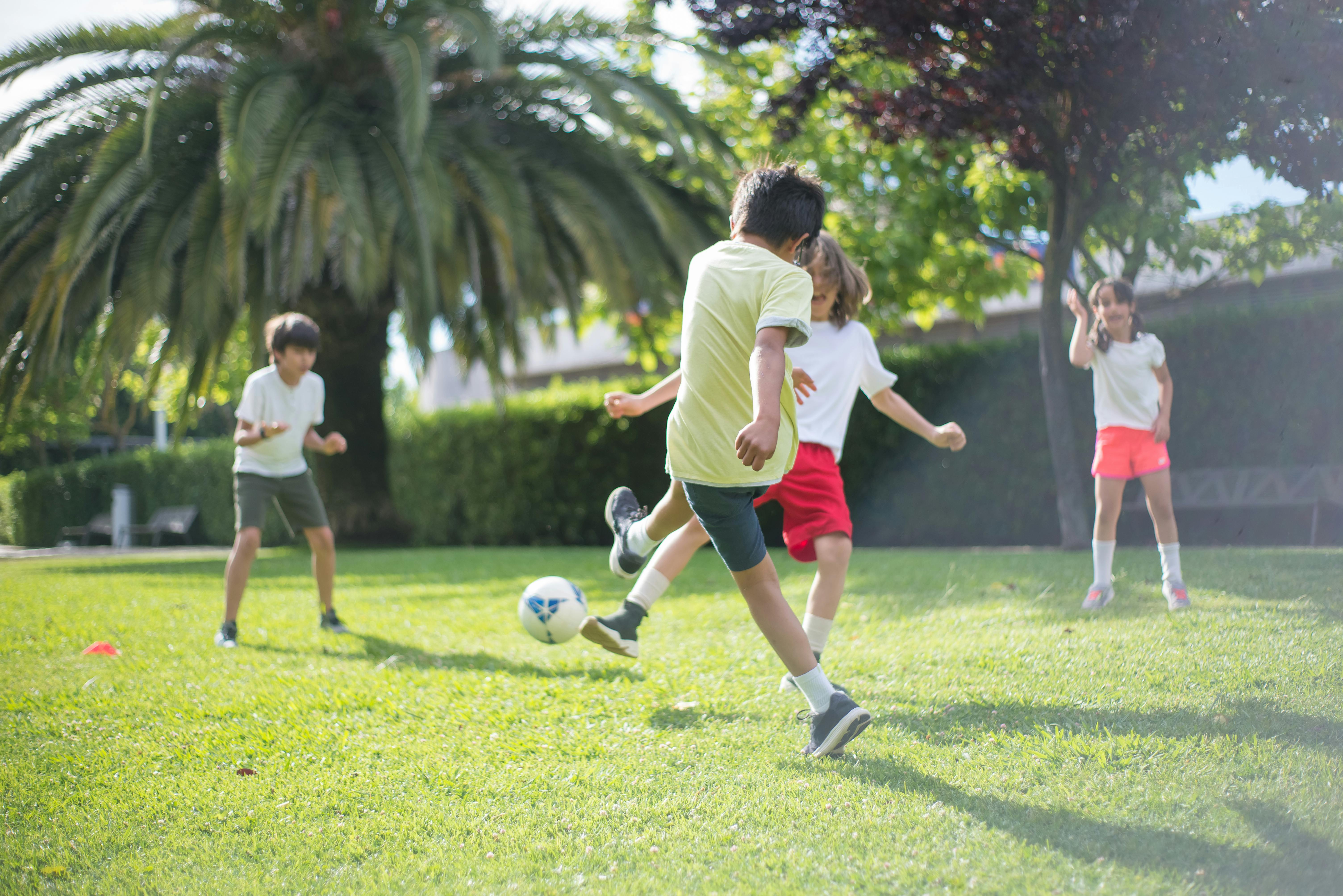 Niños jugando al fútbol en el campo | Fuente: Pexels