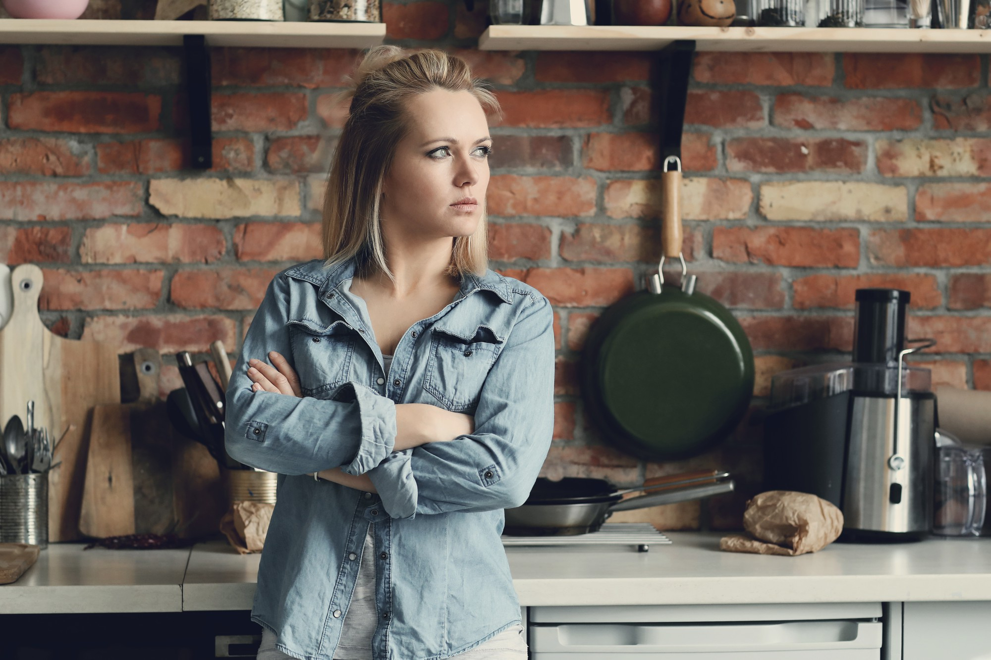 Una mujer escuchando algo mientras está en la cocina | Fuente: Freepik