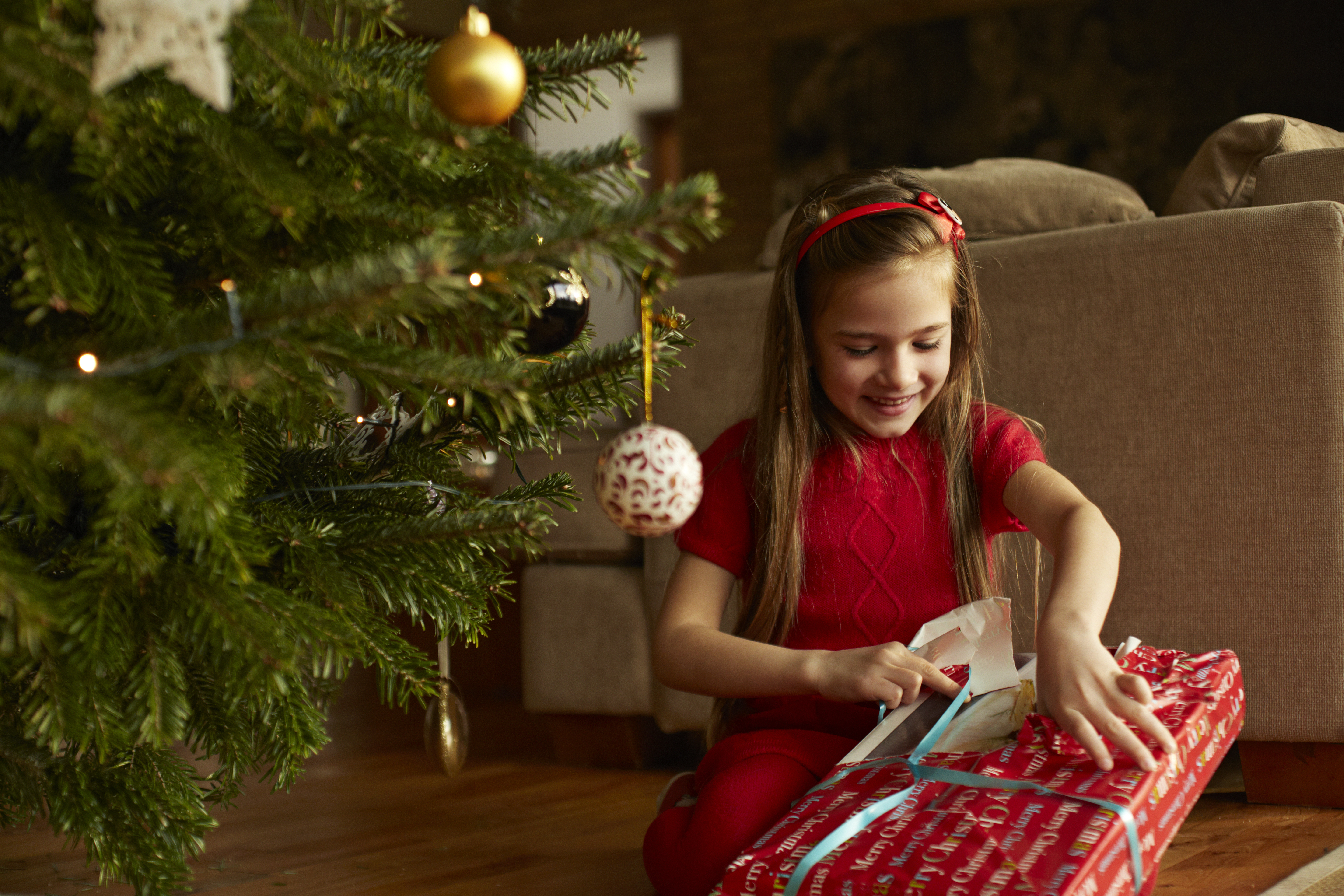 Niña abriendo un regalo de Navidad | Foto: Getty Images