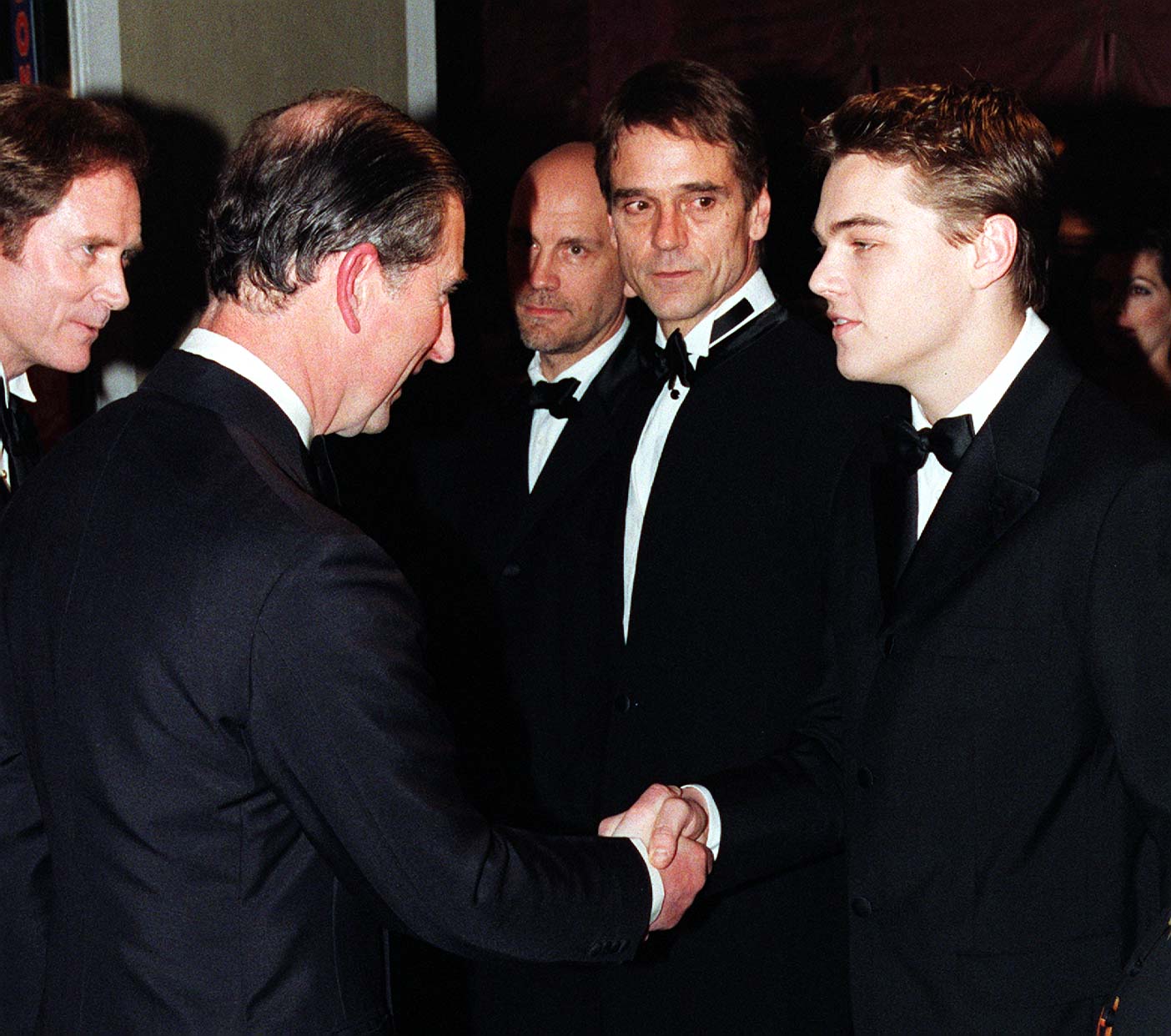 Charles, príncipe de Gales (ahora rey Charles III) estrecha la mano de Leonardo DiCaprio en el estreno real de "The Man in the Iron Mask" el 19 de marzo de 1998 | Foto: Getty Images