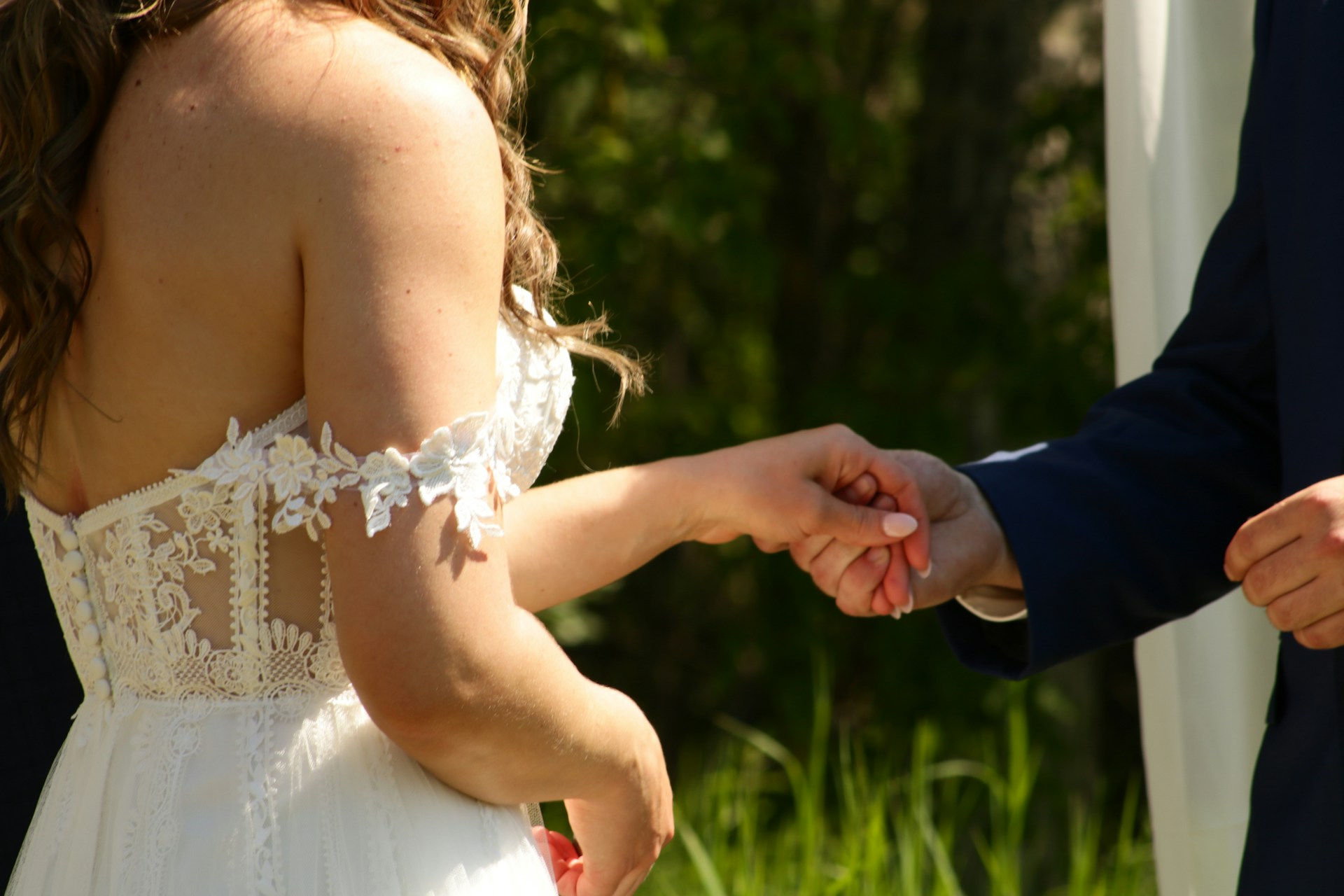 Foto recortada de un novio tomando la mano de la novia | Fuente: Unsplash