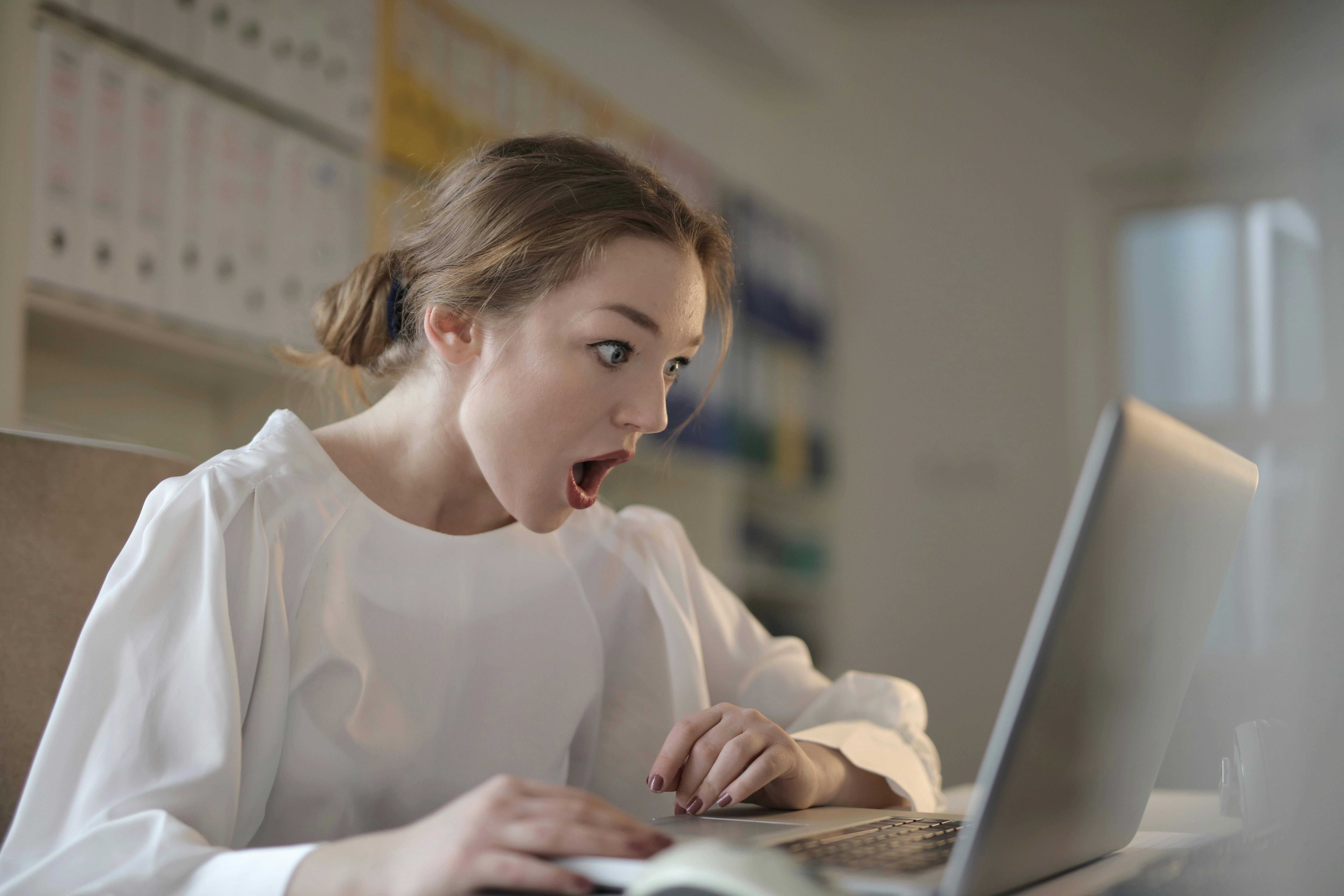 Una mujer sorprendida mirando un portátil | Fuente: Pexels