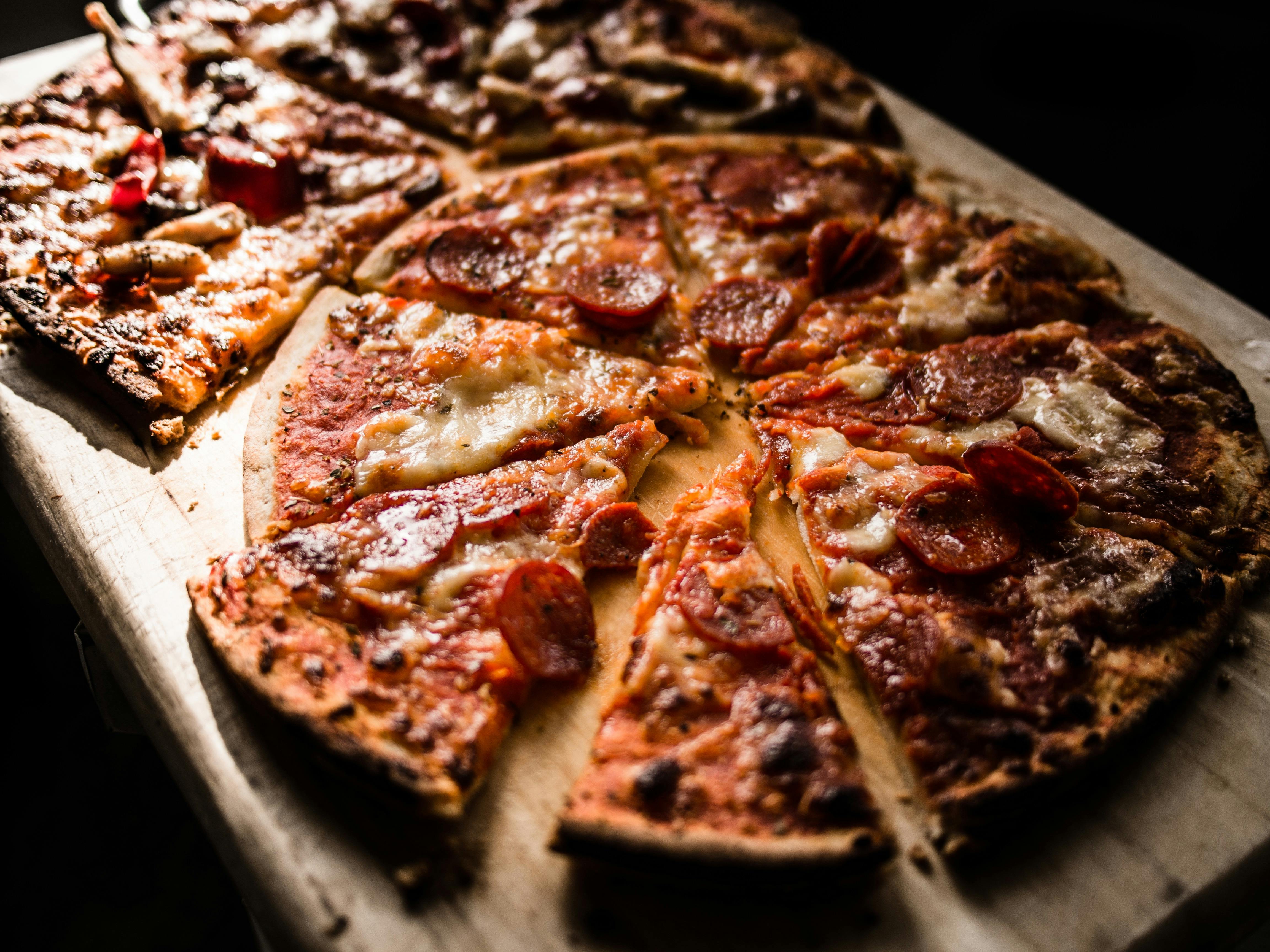 Una pizza en porciones | Fuente: Pexels