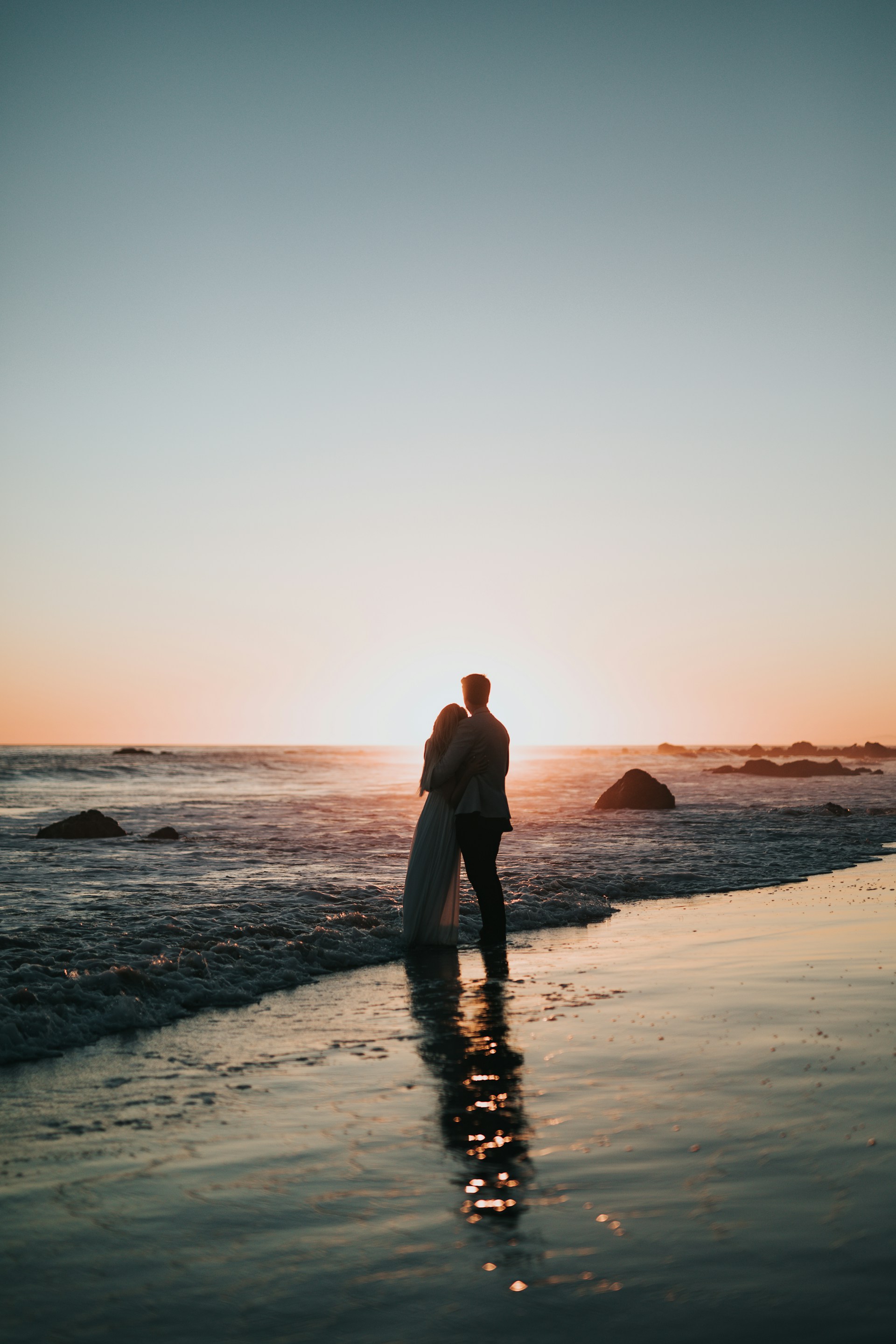 Una pareja abrazándose en la playa | Fuente: Unsplash