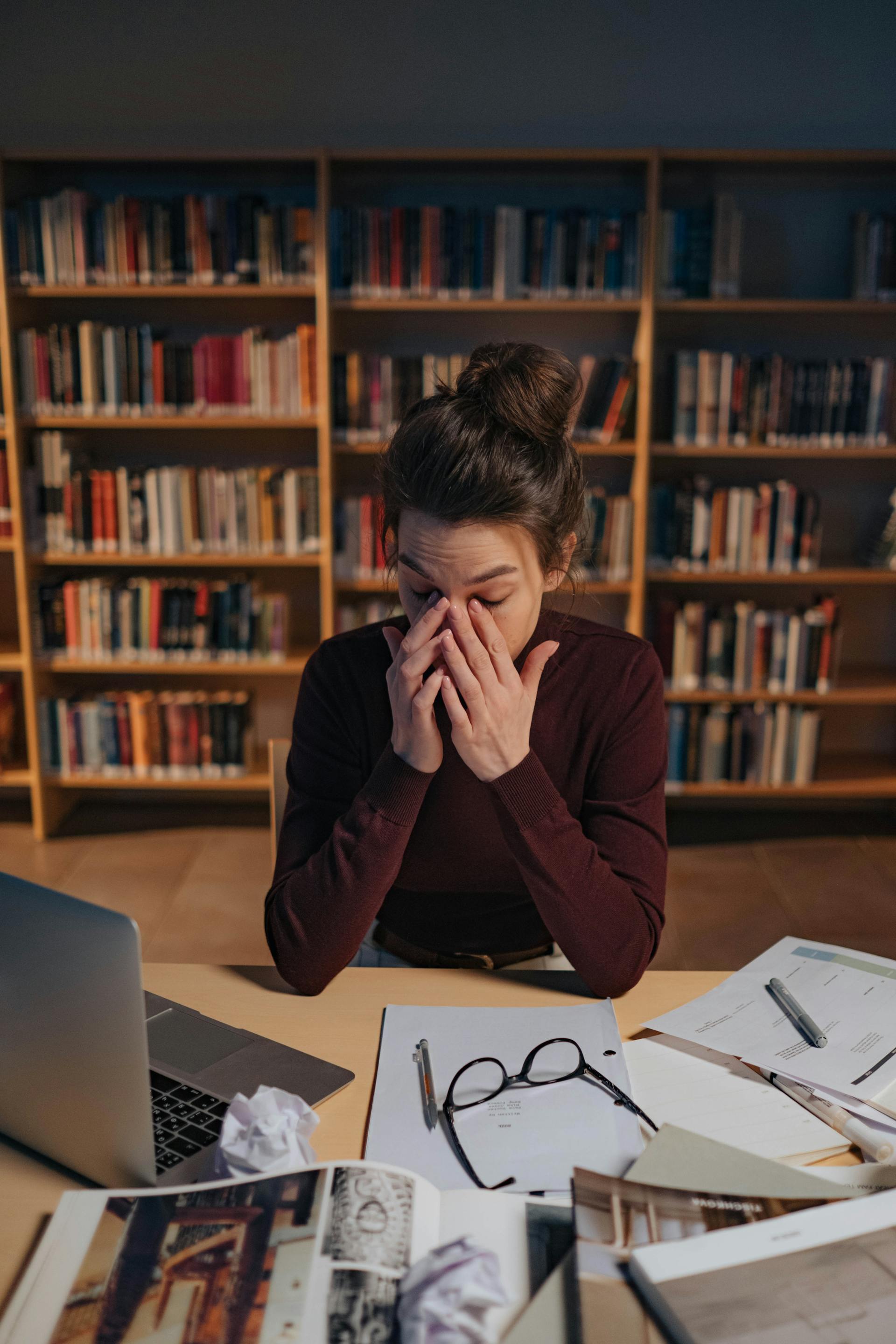 Una mujer estudiando en una biblioteca | Fuente: Pexels