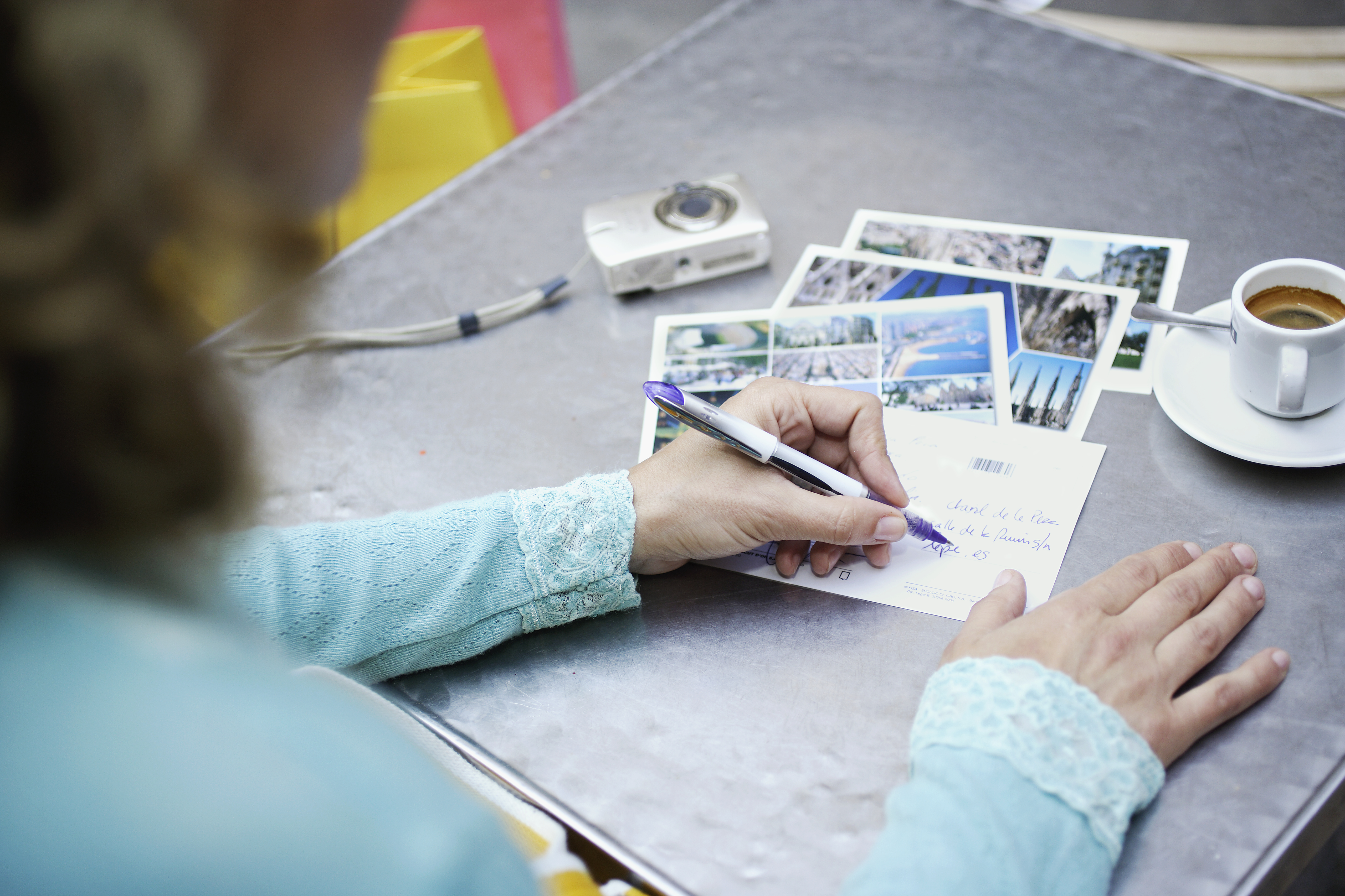 Una mujer escribiendo en el reverso de las postales | Foto: Getty Images