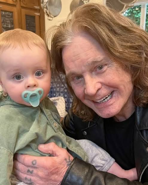 Ozzy Osbourne sonreía con ternura mientras sostenía a su nieto pequeño, Sidney, en una bonita foto familiar que captaba uno de los momentos más entrañables que compartieron antes de la muerte de la leyenda del rock. | Fuente: Instagram/@kellyosbourne