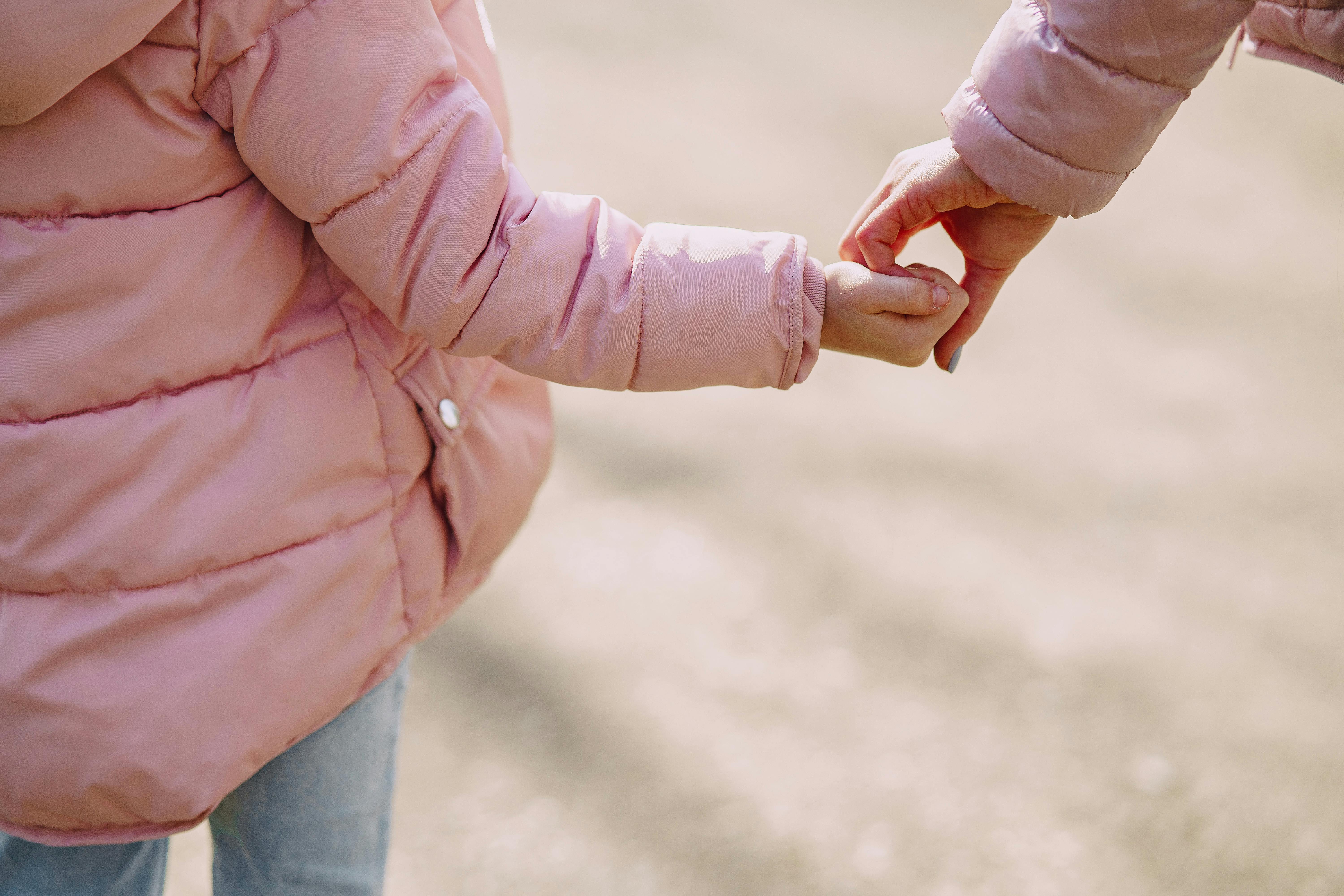 Una madre cogiendo de la mano a su hija pequeña | Fuente: Pexels