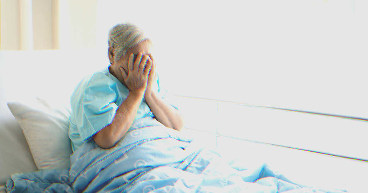 Mujer llorando en la cama de un hospital | Fuente: Shutterstock