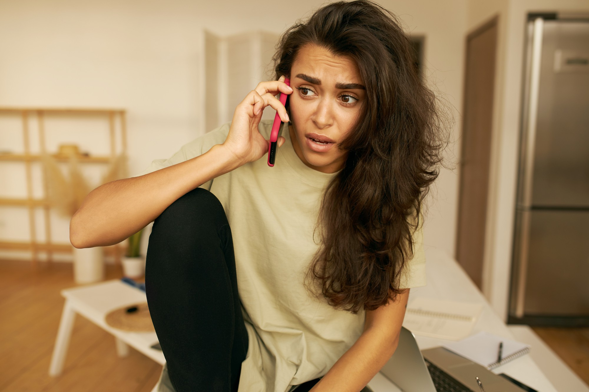 Una mujer con cara de sorpresa mientras habla por teléfono | Foto: Freepik