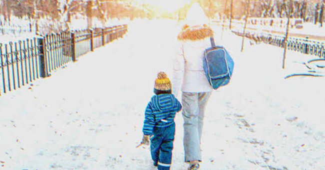 Una mujer y un niño caminando de la mano | Fuente: Shutterstock