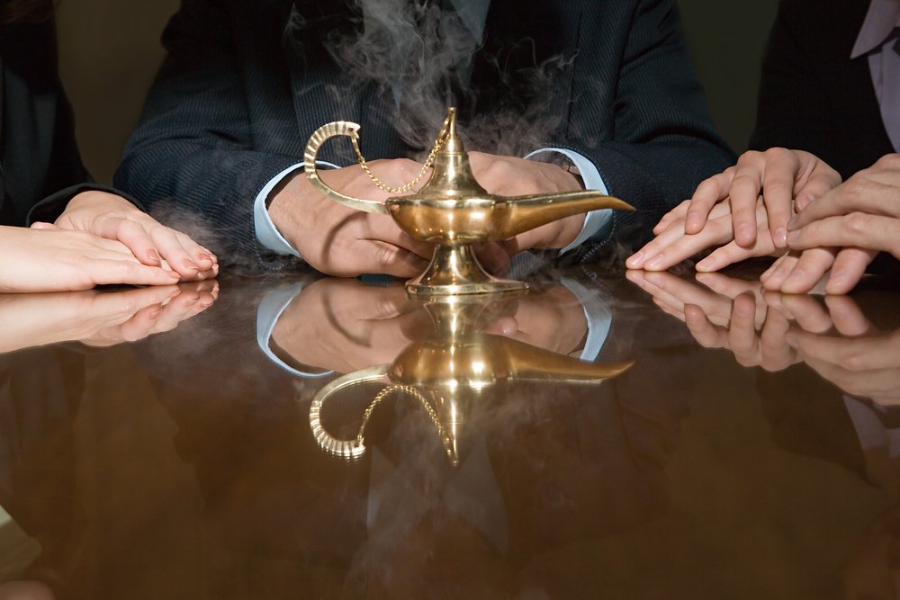 Varias personas sentadas alrededor de una mesa con una lámpara “mágica” sobre ella. | Foto: Shutterstock