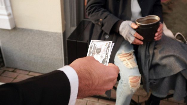 Hombre entregando billetes a anciano. │Foto: Freepik