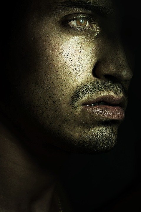 Hombre joven llorando en la oscuridad. | Imagen: Max Pixel