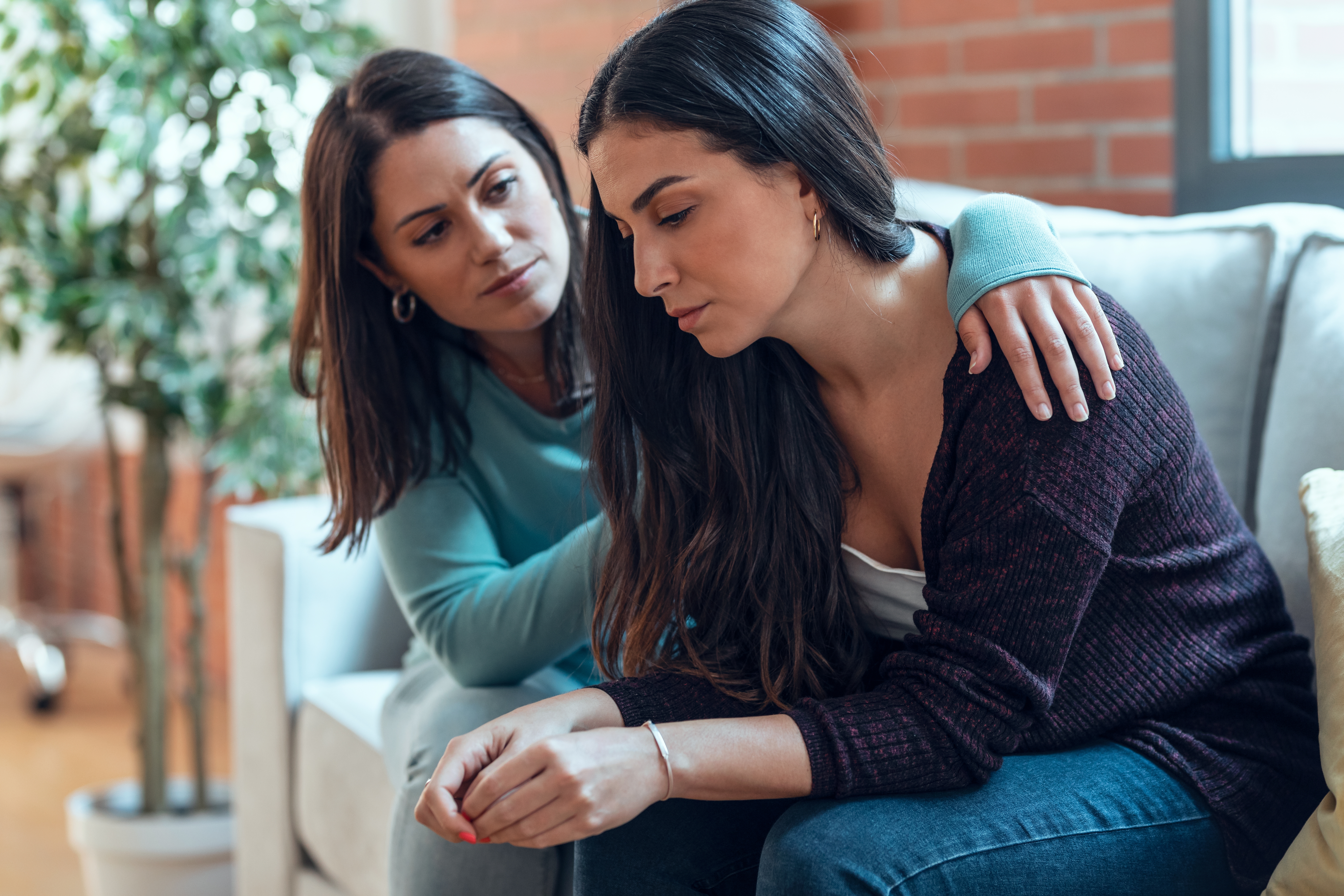 Instantánea de una guapa joven apoyando y consolando a su triste amiga | Fuente: Shutterstock