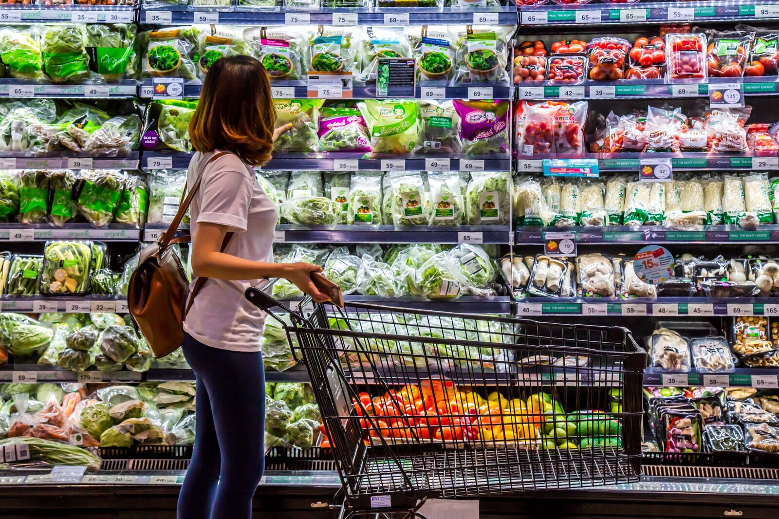 Mujer inspecciona verduras en supermercado. Fuente: Shutterstock