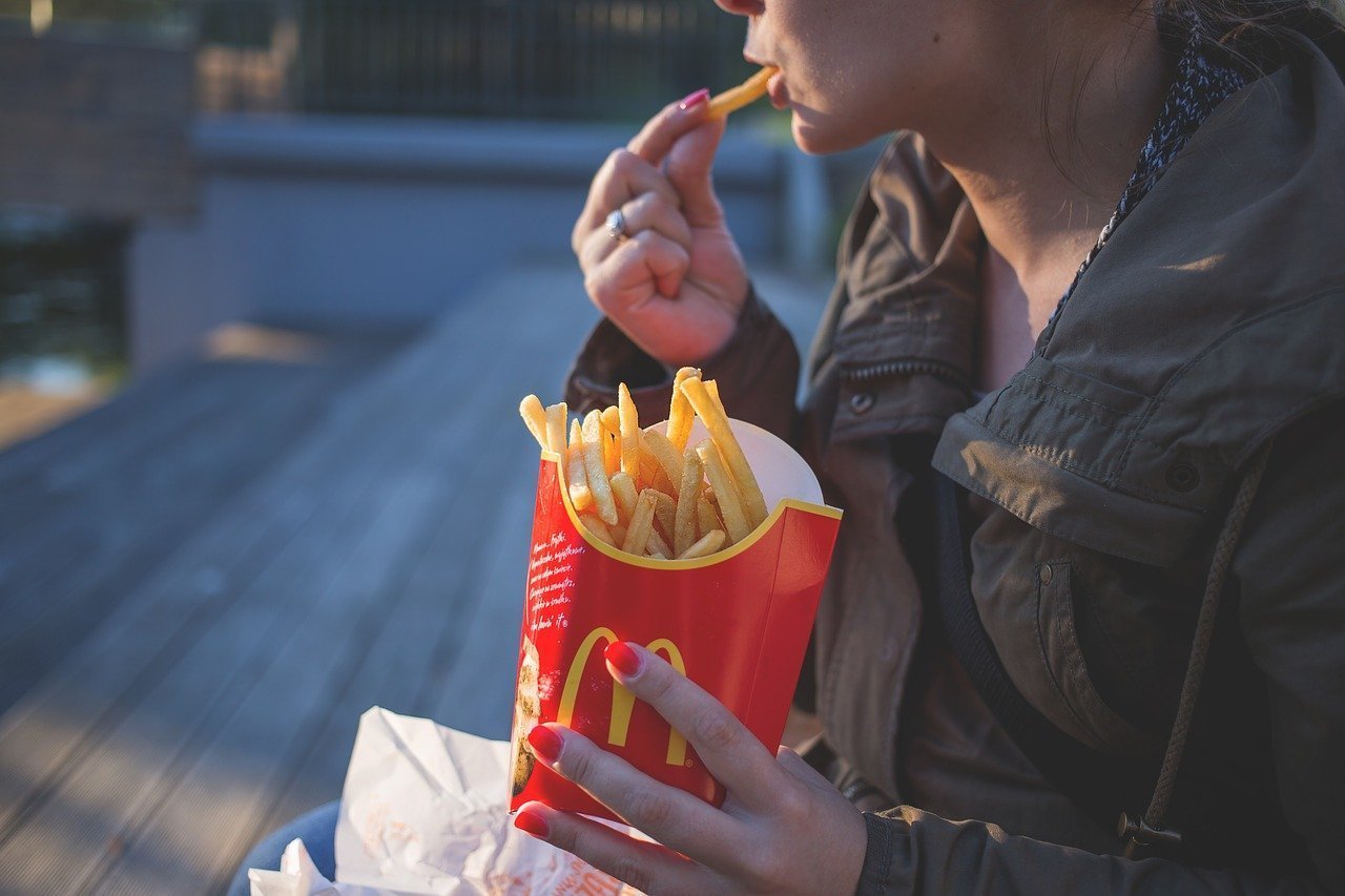 Adolescente comiendo papas fritas. | Imagen tomada de: Pixabay