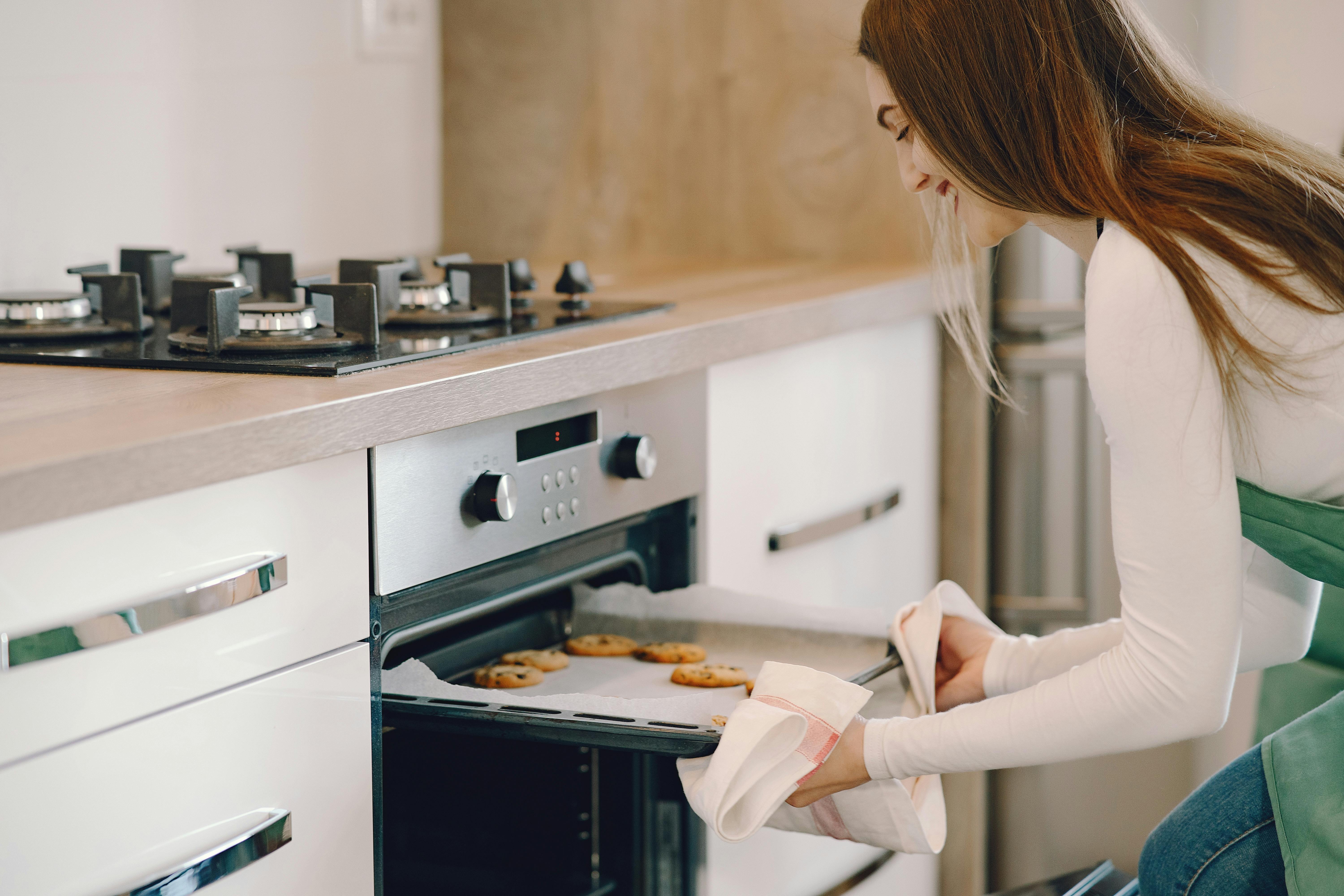 Mujer sacando galletas | Fuente: Pexels