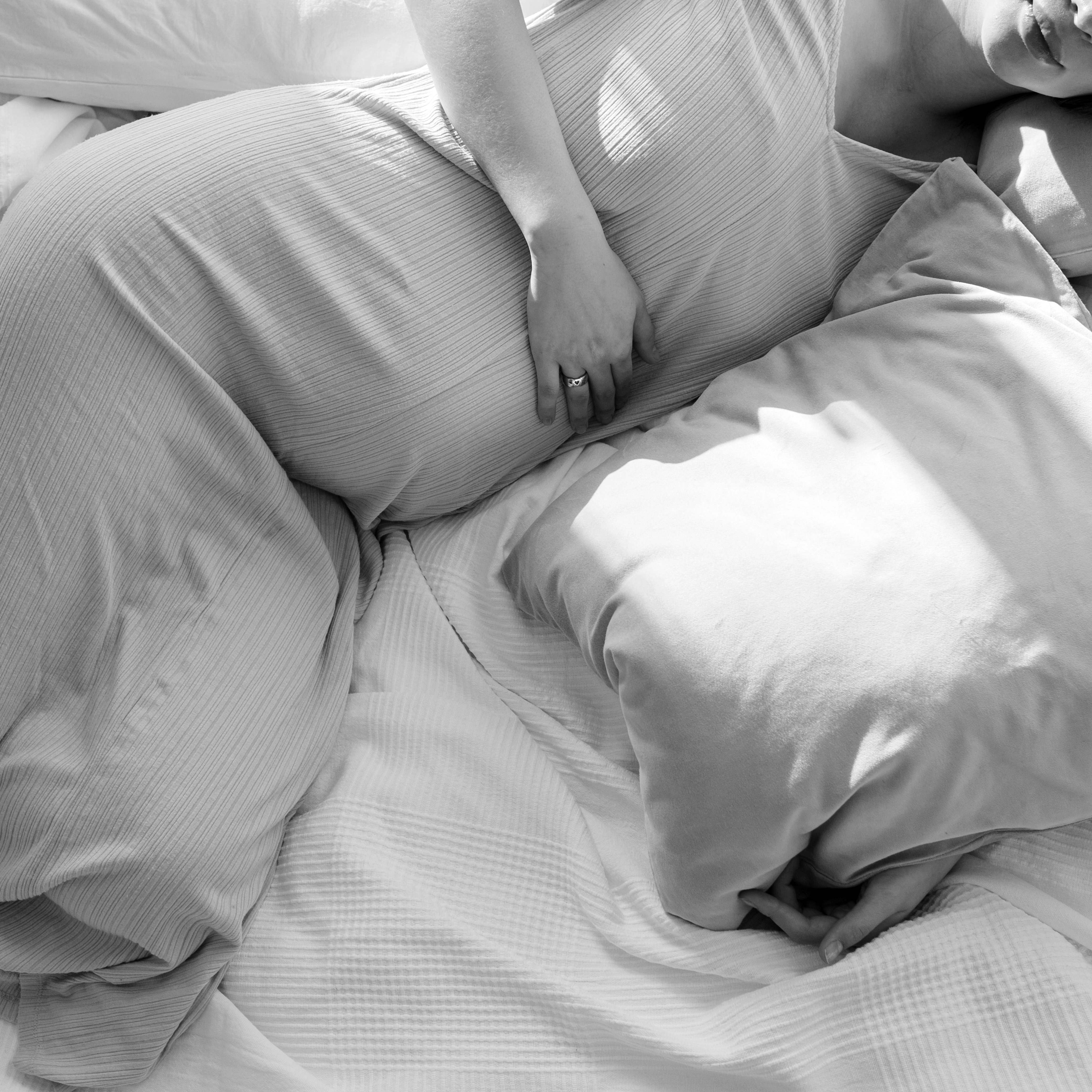 Una mujer embarazada reclinada en la cama | Fuente: Pexels