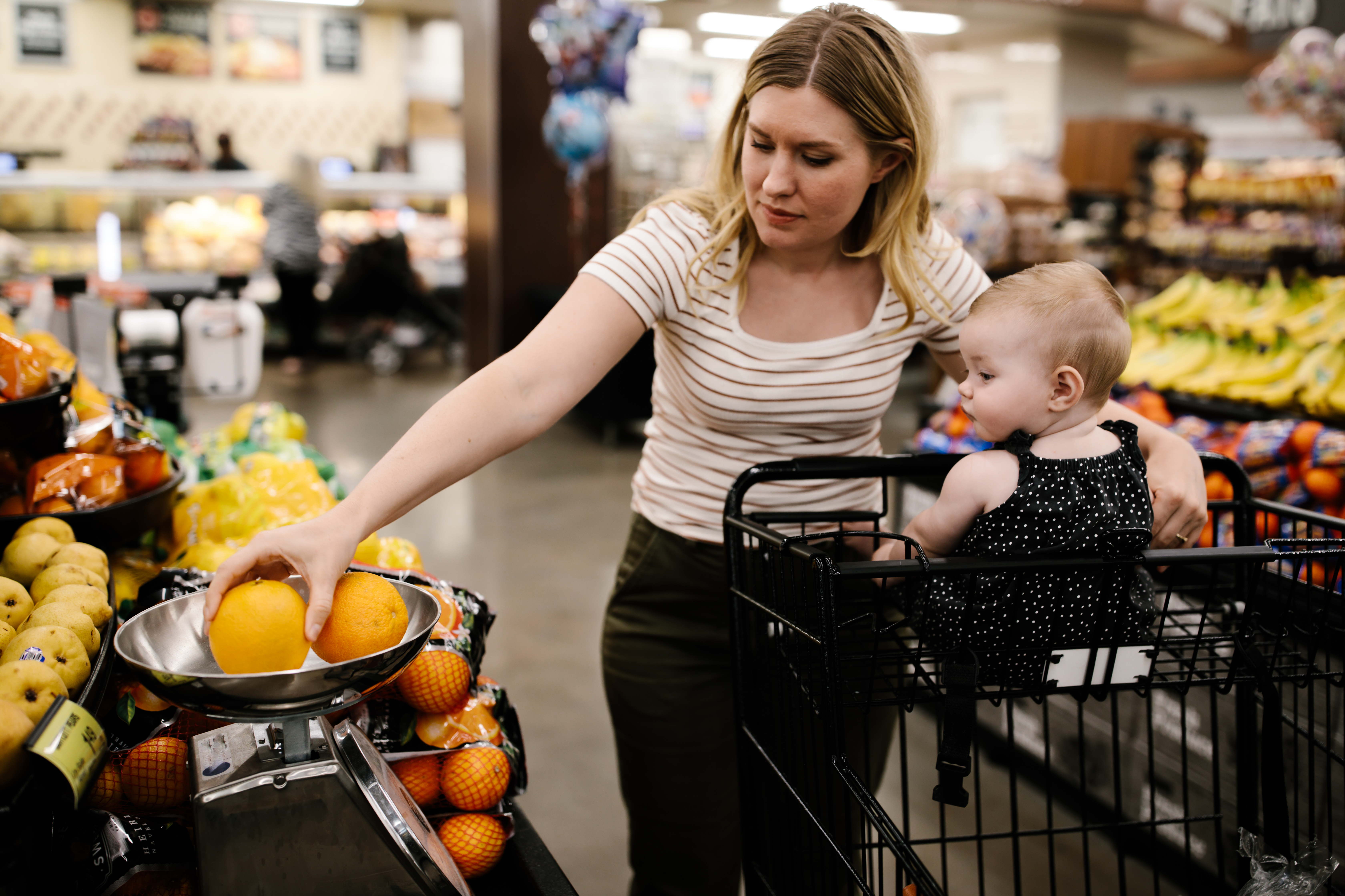 Una madre con su hija pequeña comprando fruta fresca en el supermercado | Foto: Getty Images