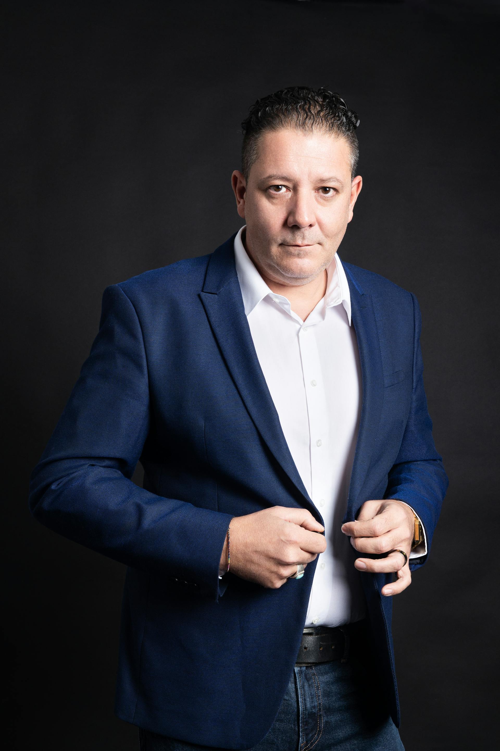 Un hombre ajustándose la chaqueta | Fuente: Pexels