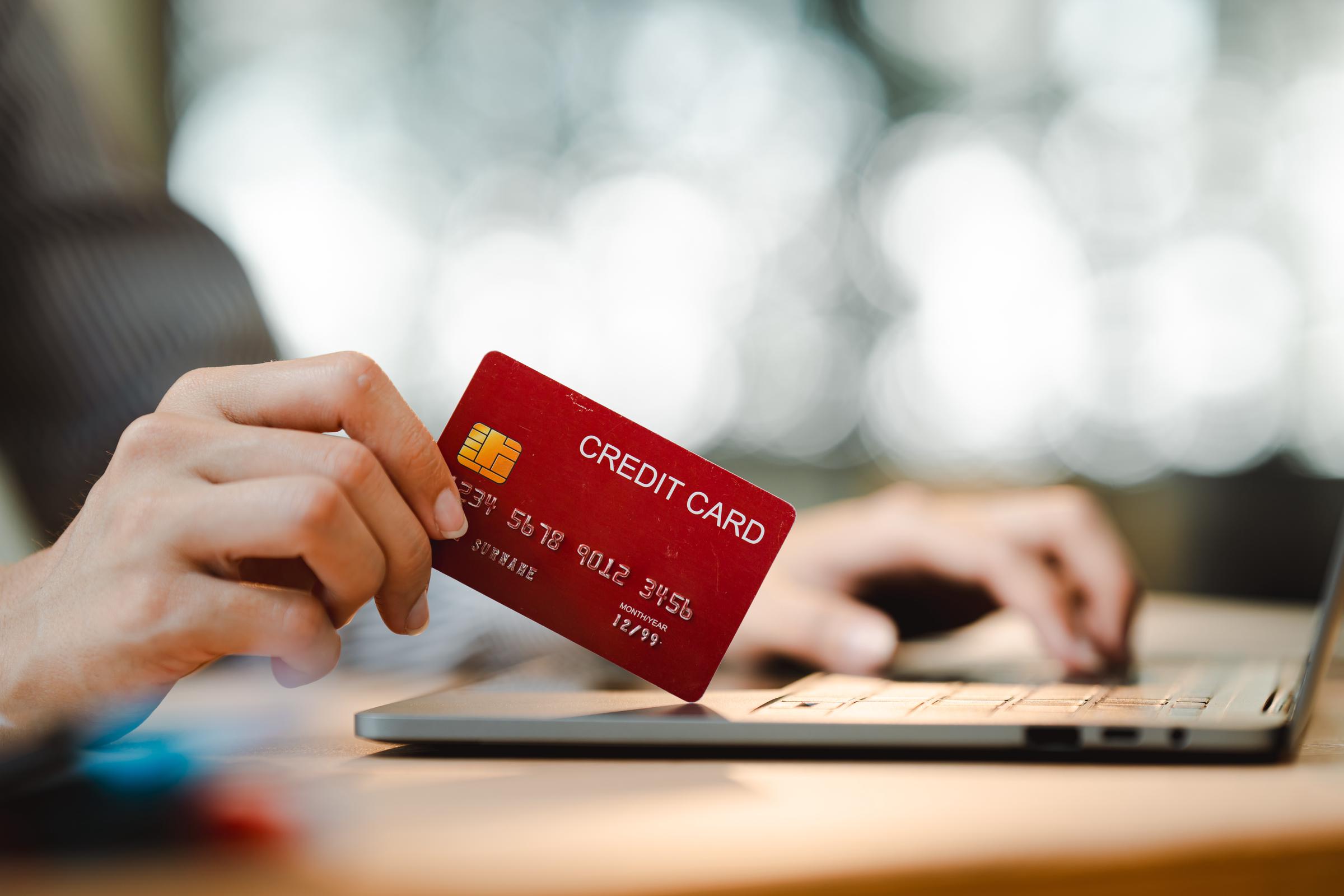 Una persona introduciendo los datos de una tarjeta de crédito en un portátil | Fuente: Shutterstock