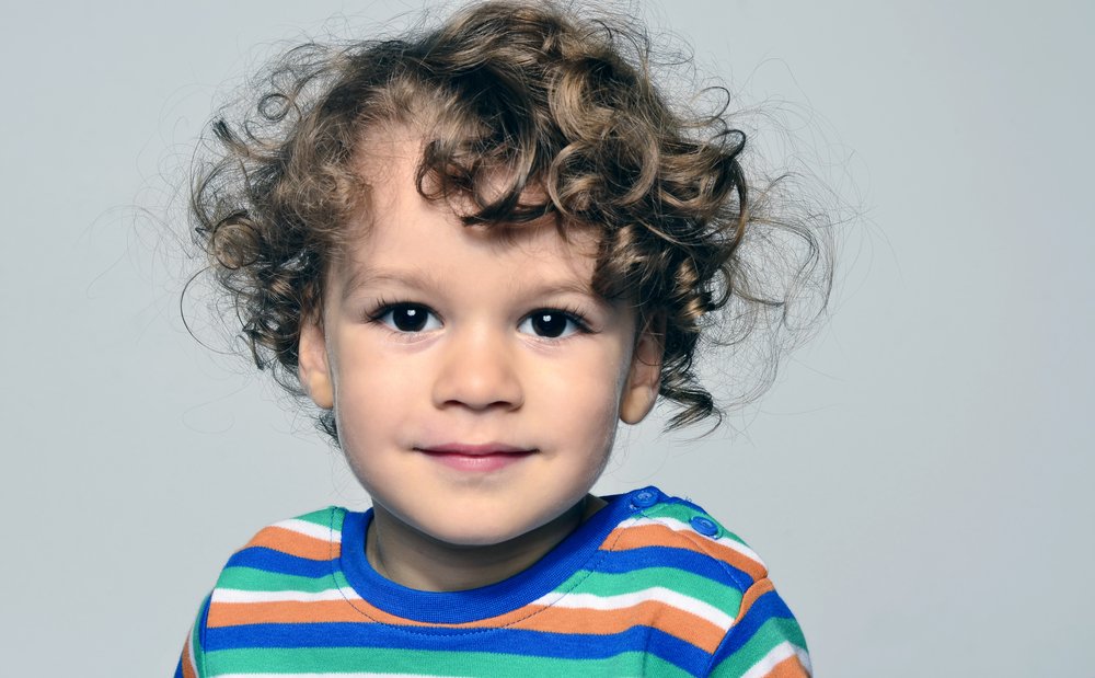 Niño de ojos negros y rulos. | Foto: Shutterstock