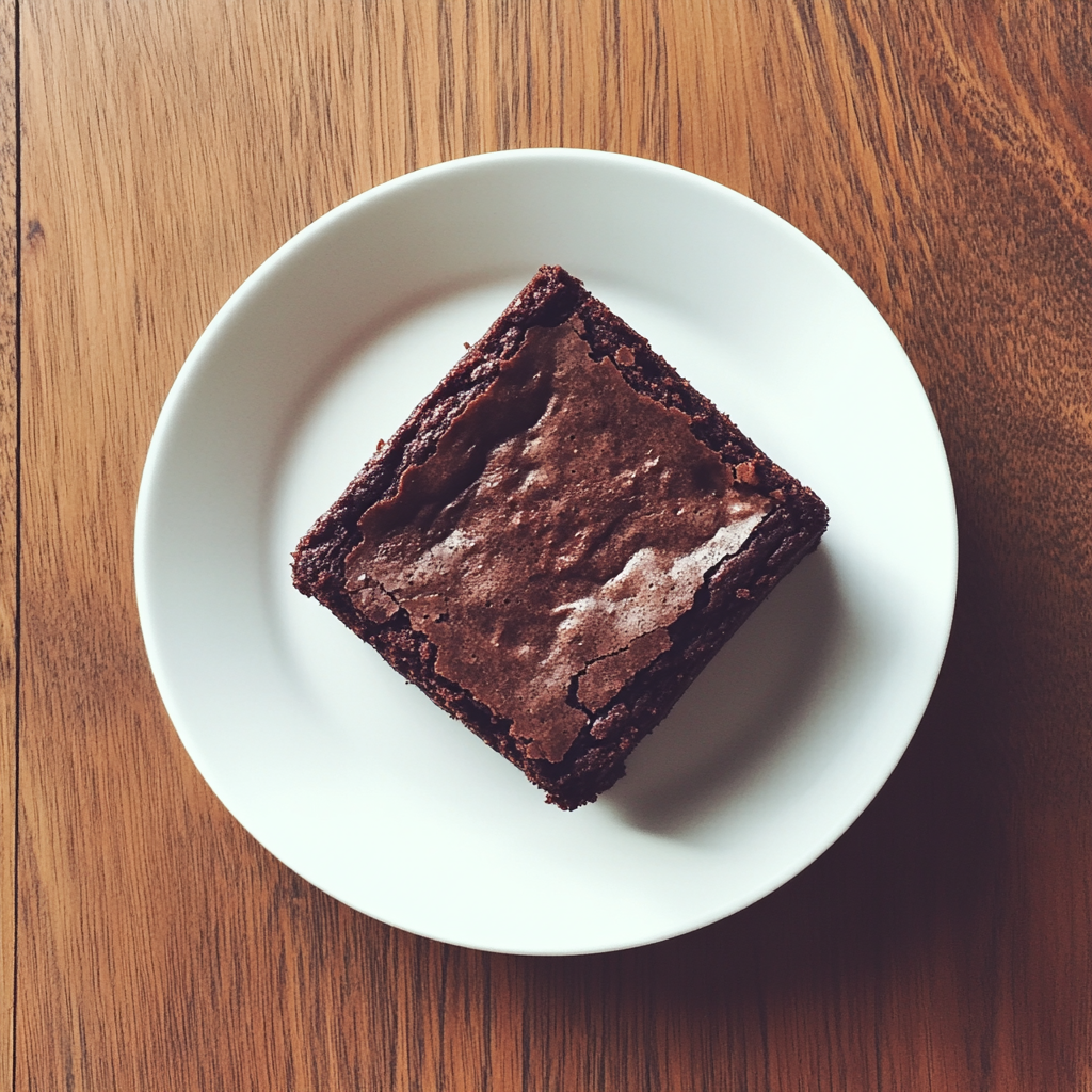 Un brownie en un plato | Fuente: Midjourney
