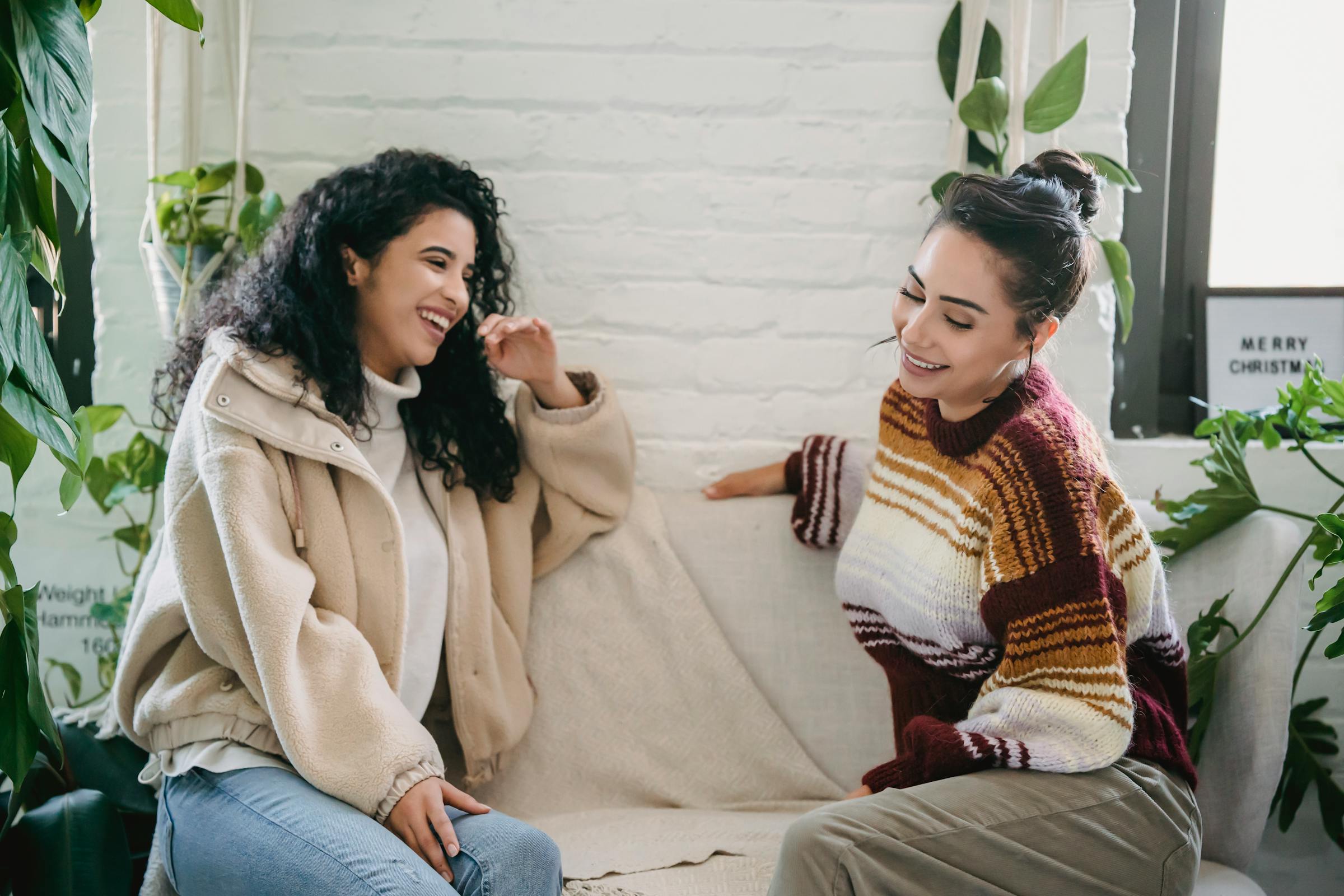 Dos mujeres riendo en un sofá | Fuente: Pexels