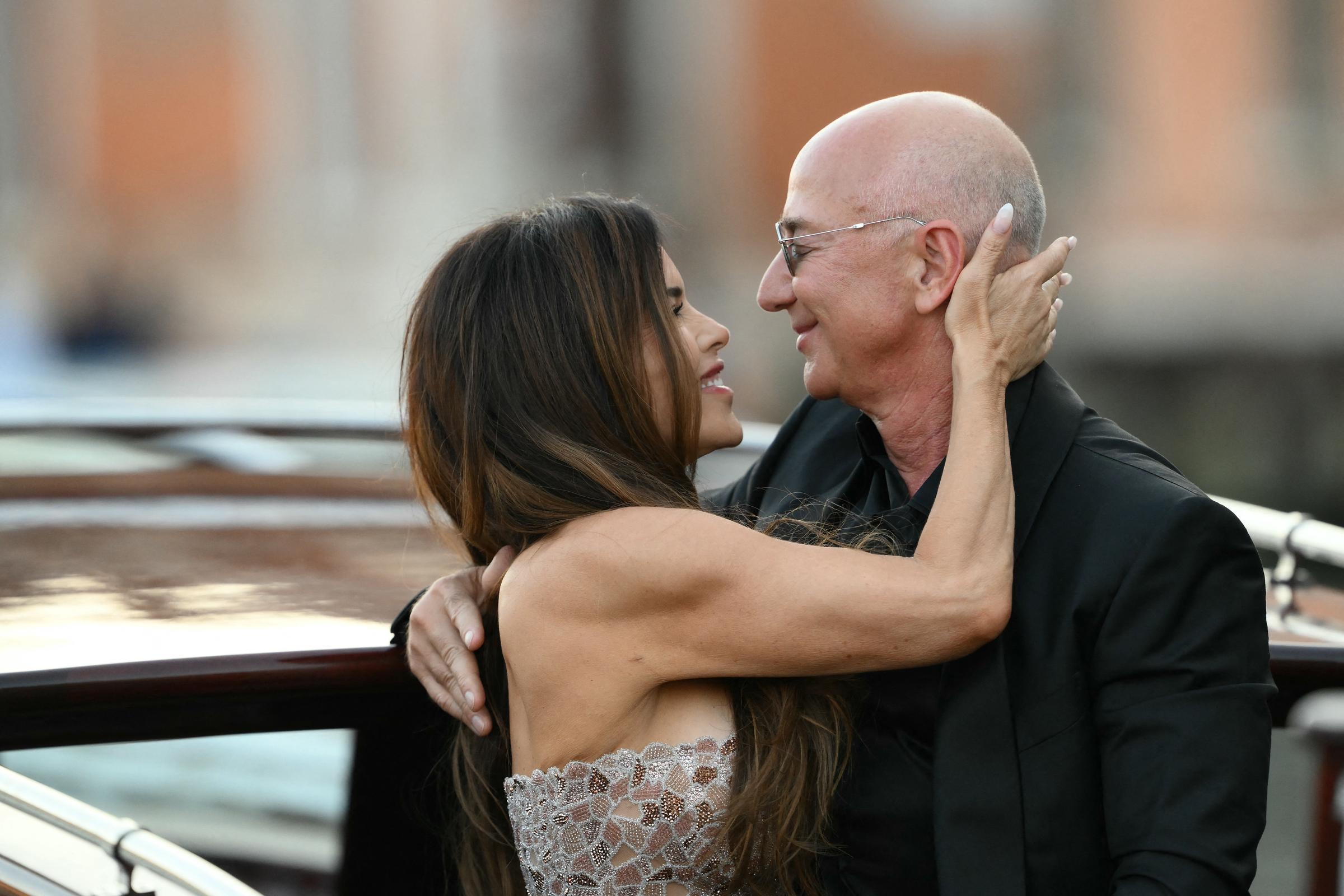 Lauren Sánchez mira cariñosamente a Jeff Bezos, con la mano apoyada suavemente en el costado de su cabeza mientras comparten un momento íntimo a bordo del barco, con sus rostros cercanos y sonrisas suaves.