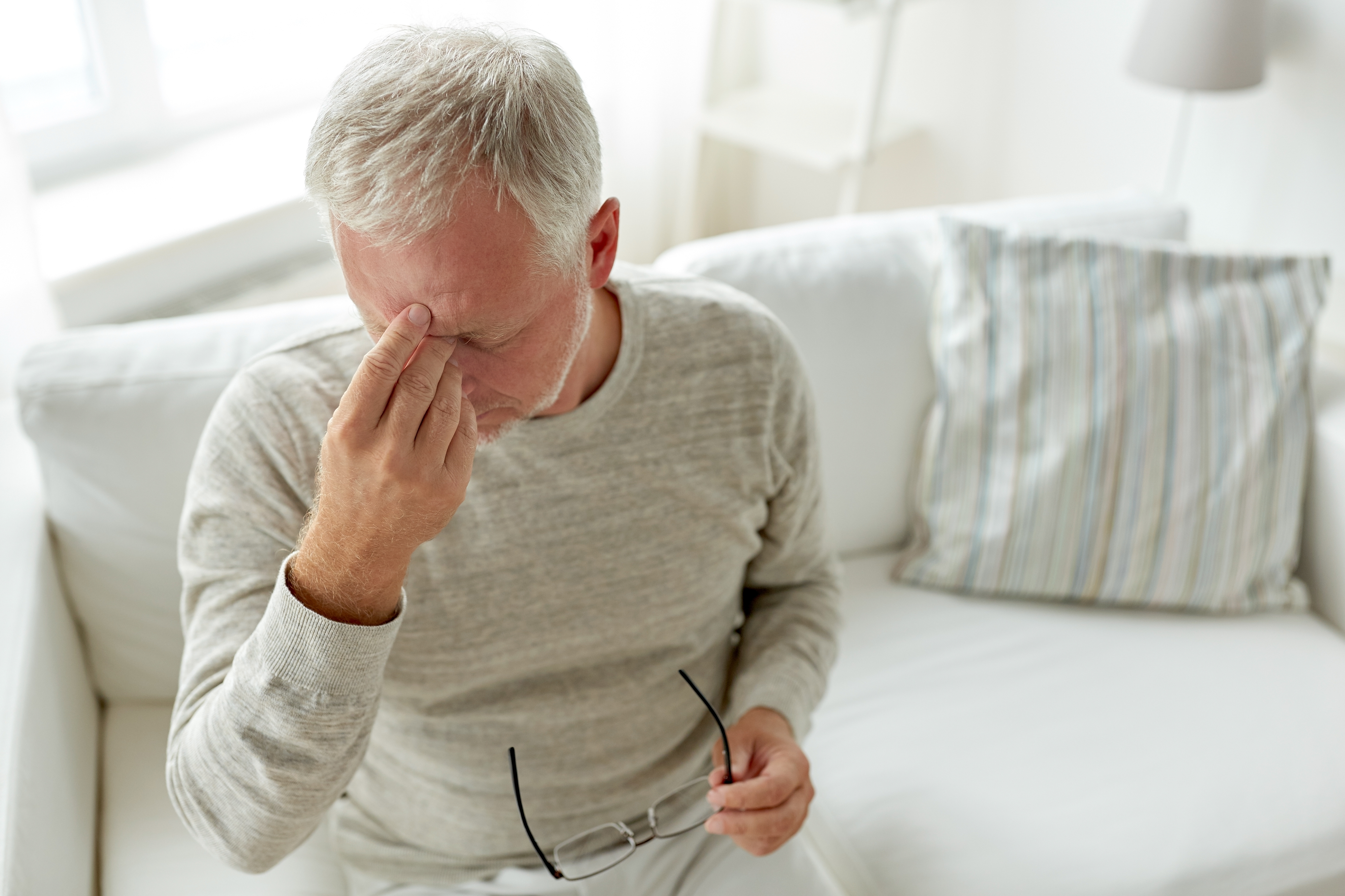 Un anciano preocupado sentado en un sofá | Fuente: Shutterstock