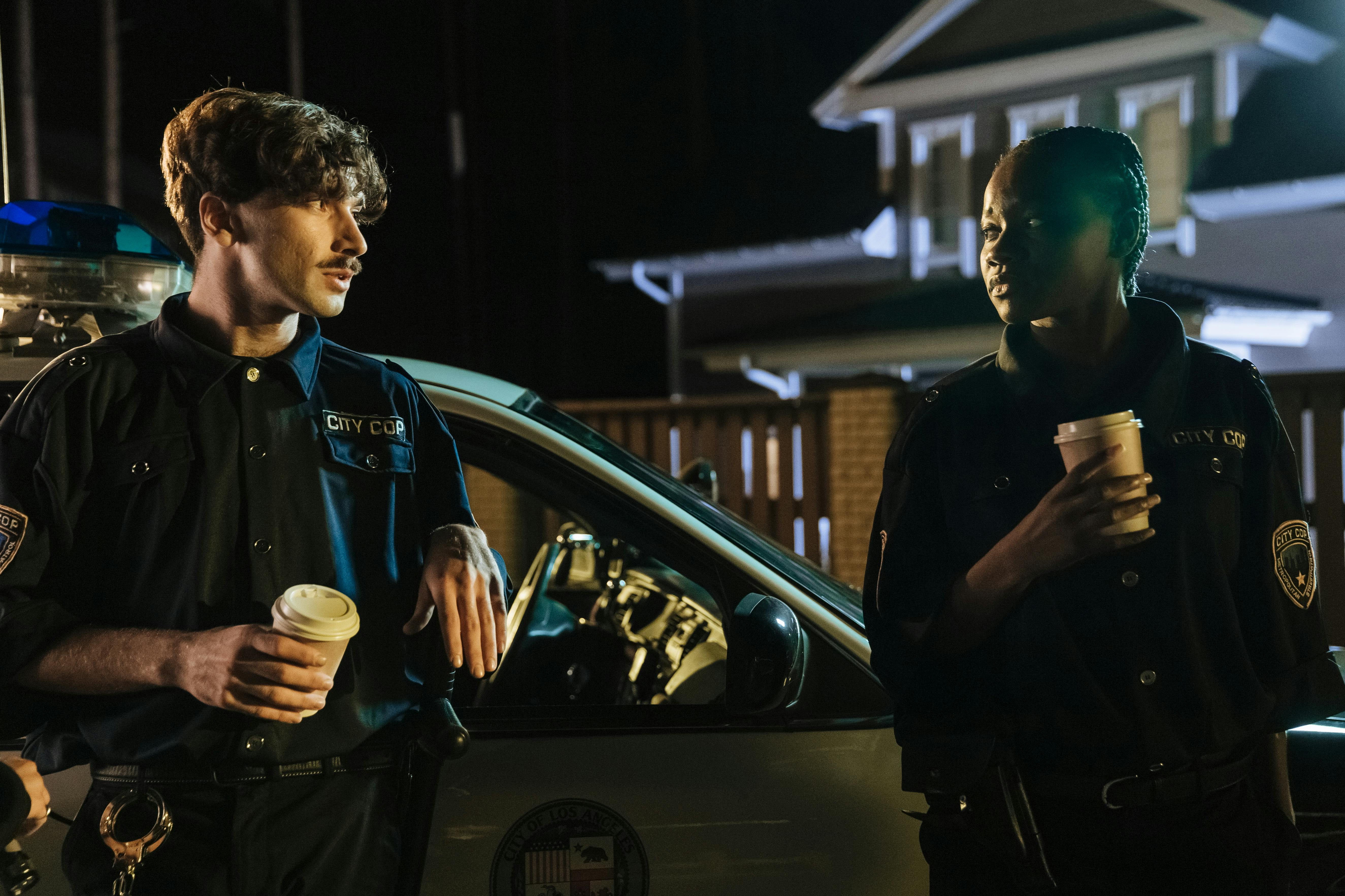 Policías junto a un coche patrulla | Fuente: Pexels