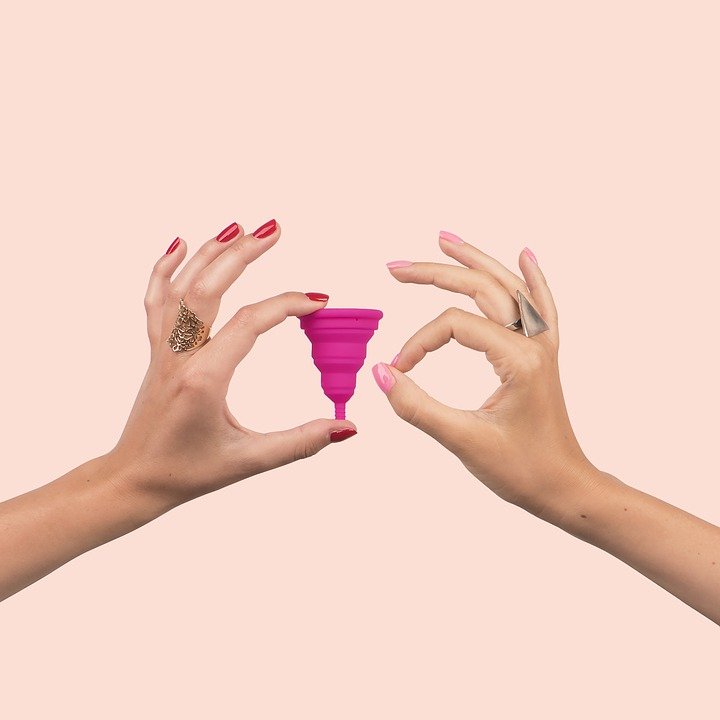Manos de mujer con copa menstrual. | Foto: Pixabay