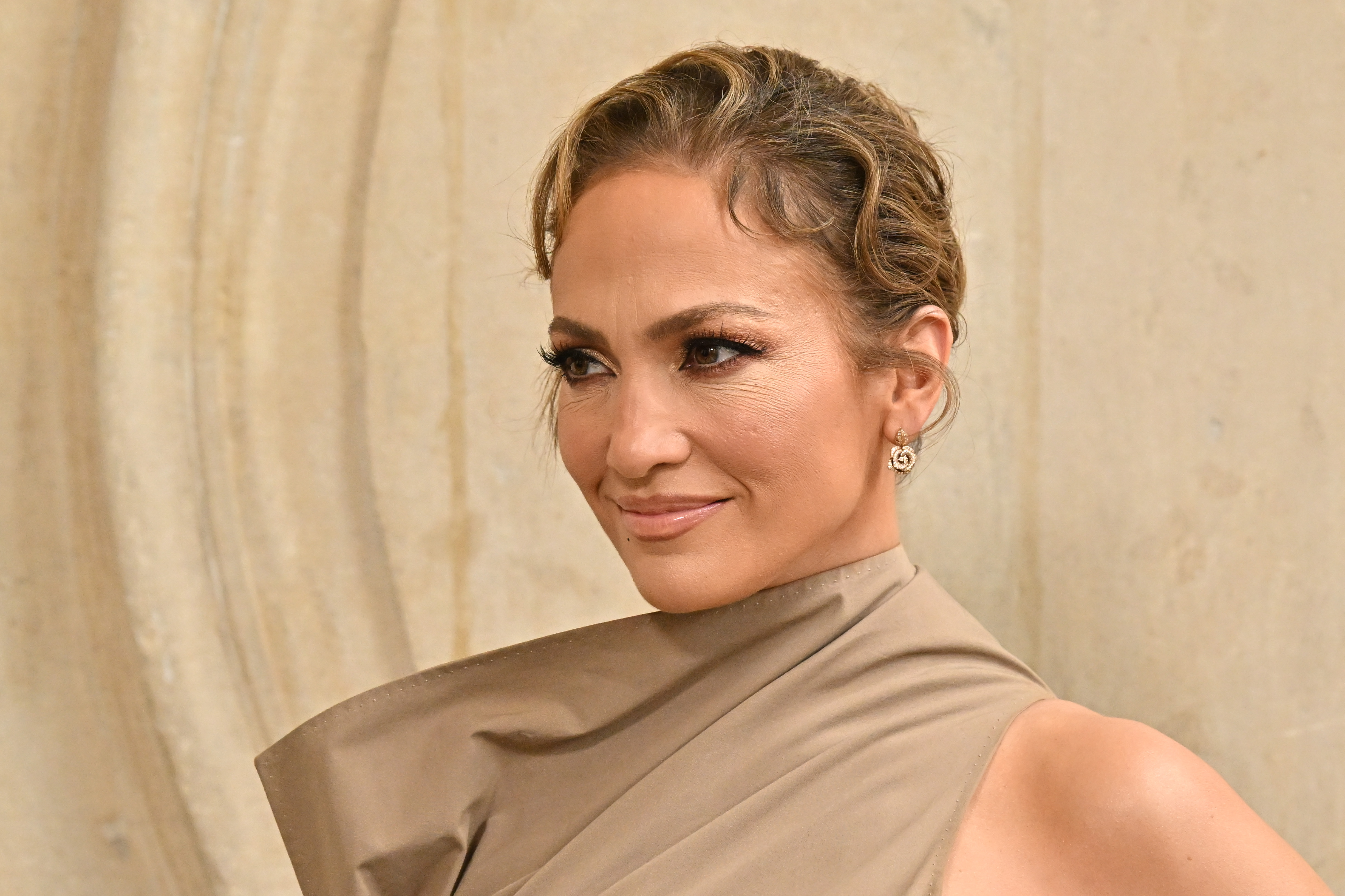 Jennifer Lopez muestra una ligera pero seria sonrisa en el desfile de Alta Costura Otoño/Invierno 2024 de Christian Dior durante la Semana de la Moda de París el 24 de junio de 2024 | Fuente: Getty Images