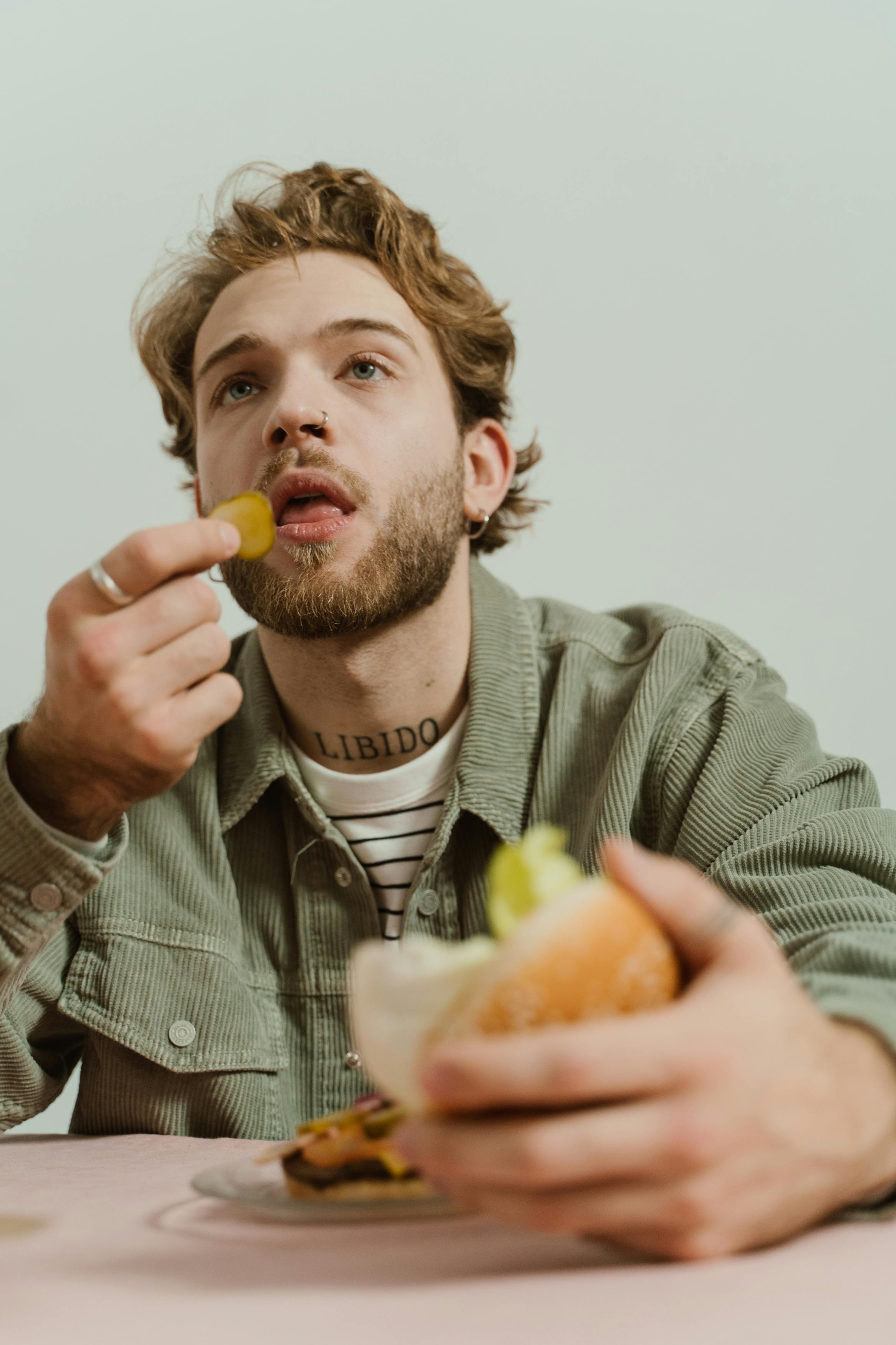 Hombre contento comiendo | Fuente: Pexels