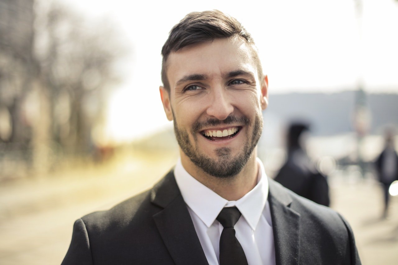 Hombre vestido de traje elegante sonriendo. | Foto: Pexels
