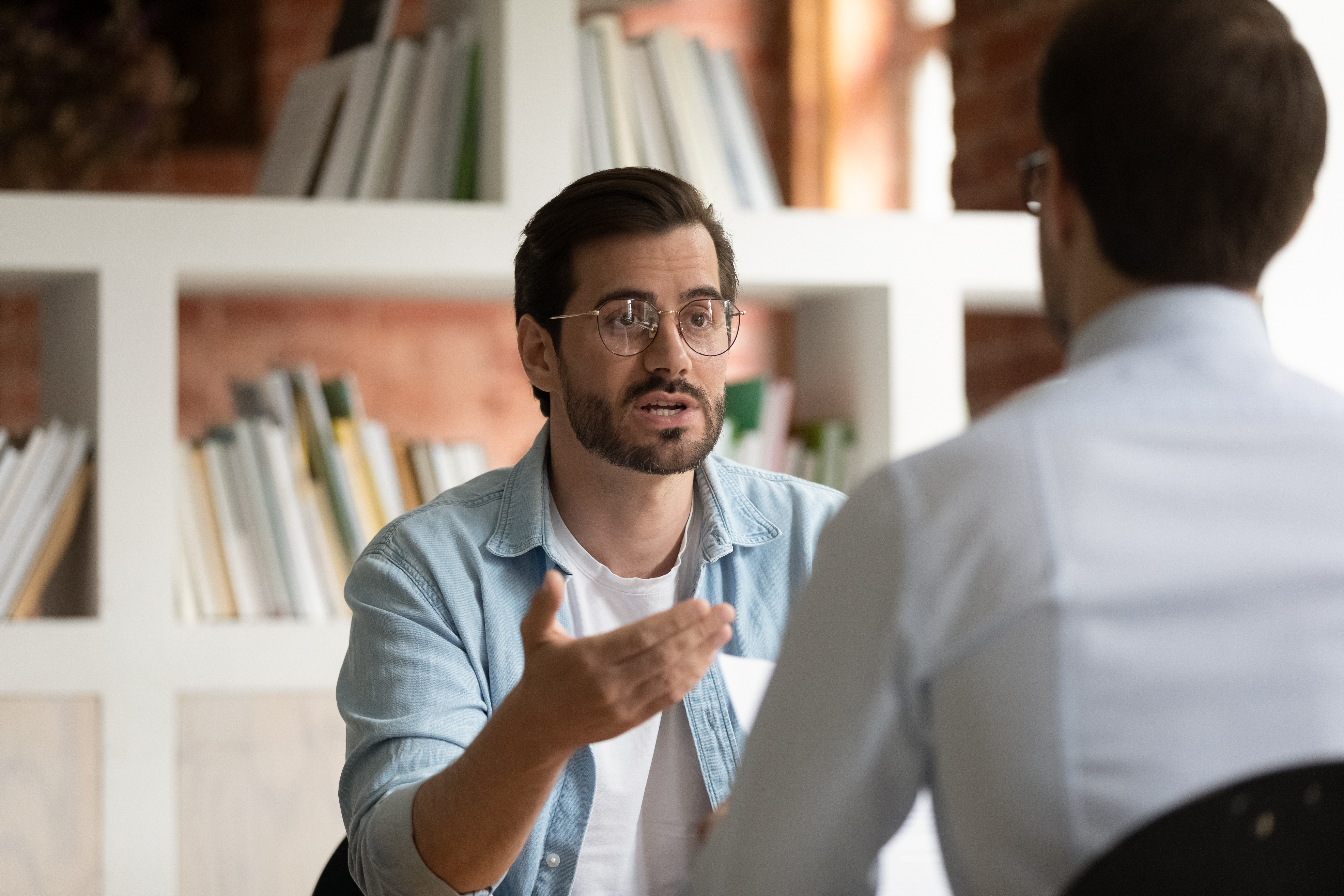 Un entrevistador hablando con un candidato a un puesto de trabajo | Fuente: Shutterstock