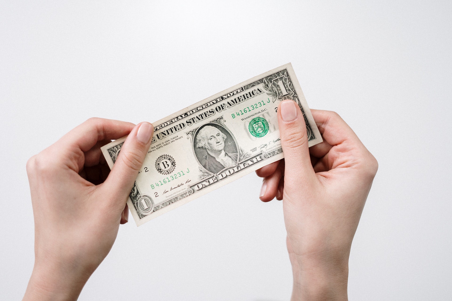 Una persona sosteniendo un billete de un dólar | Fuente: Pexels