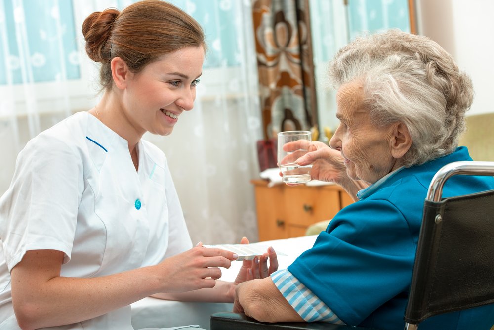 Enfermera atendiendo a una anciana en silla de ruedas. I Foto: Shutterstock