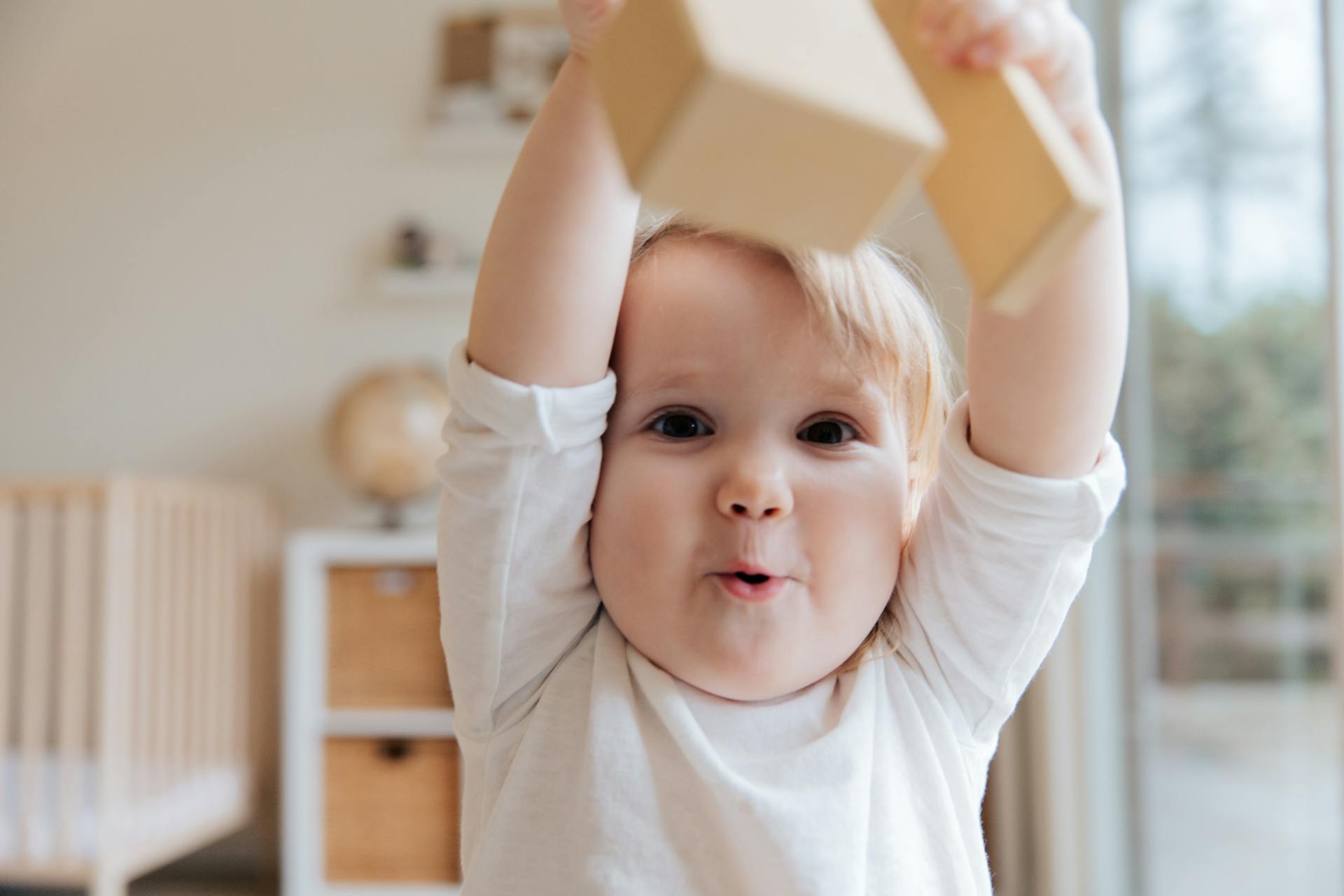 Un niño sujetando un bloque de madera | Fuente: Pexels