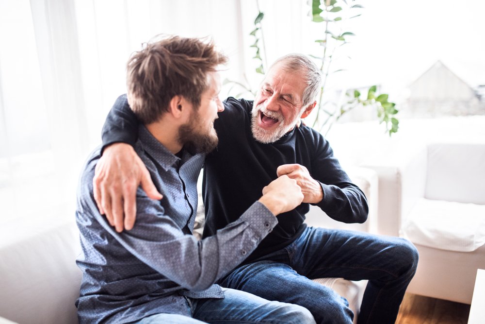 Anciano riendo con un joven. | Fuente: Shutterstock