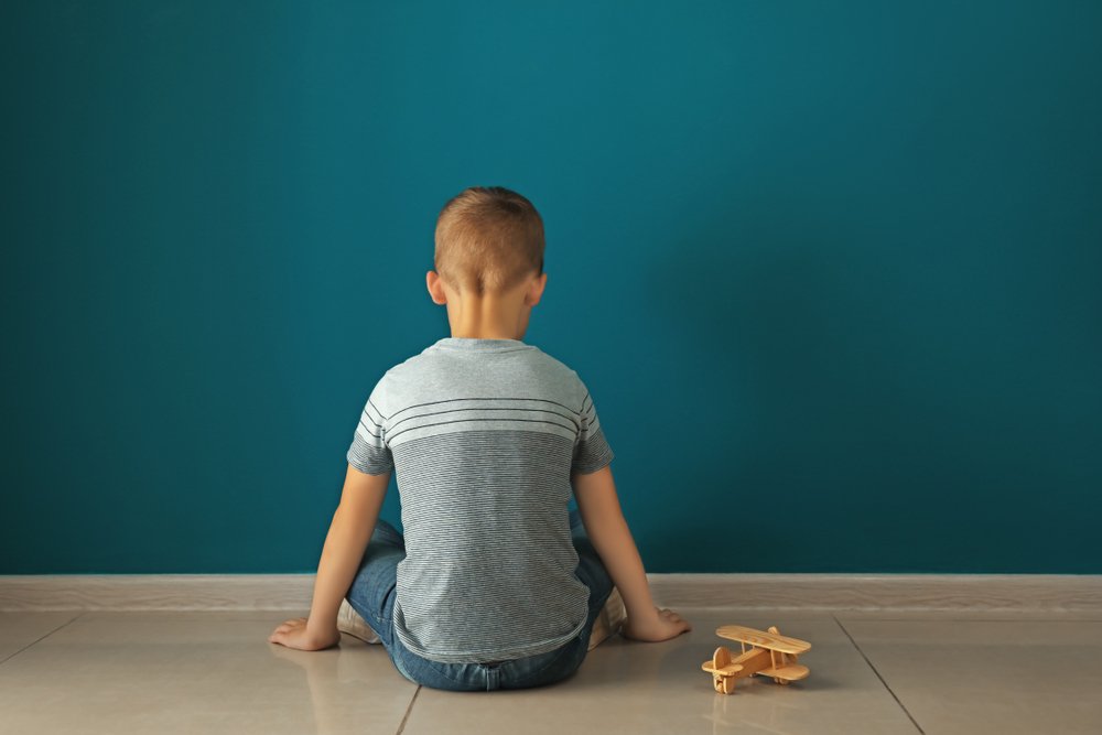 Niño sentado de frente a una pared. | Foto: Shutterstock