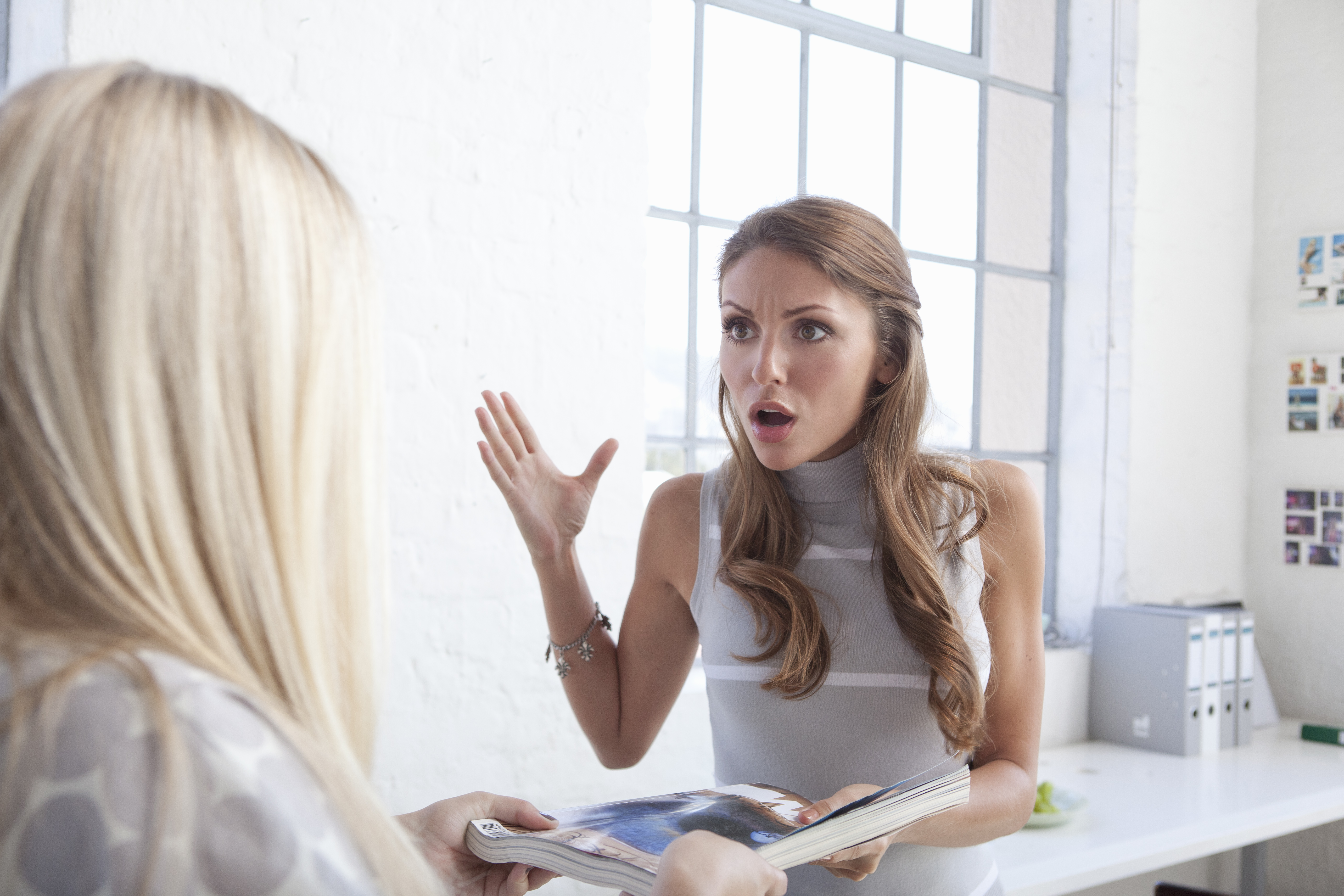 Una mujer se escandaliza mientras habla con otra mujer | Getty Images